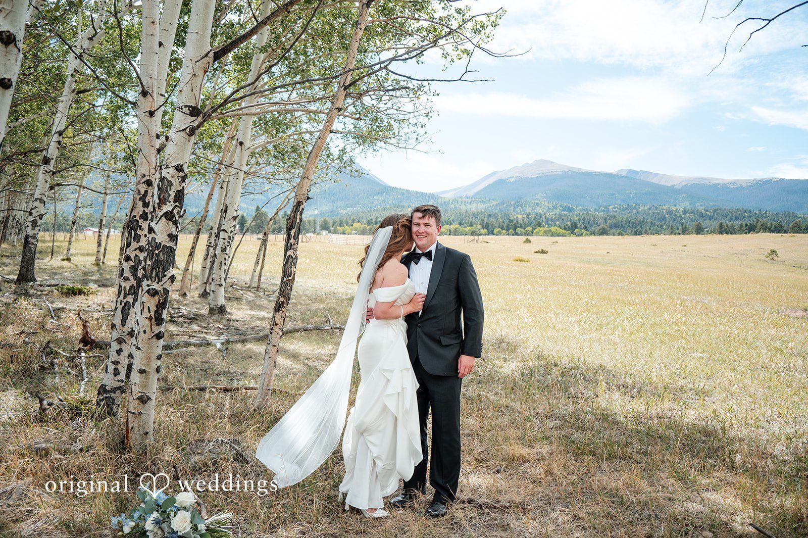 Erin + John Couple walking hand in hand across the field