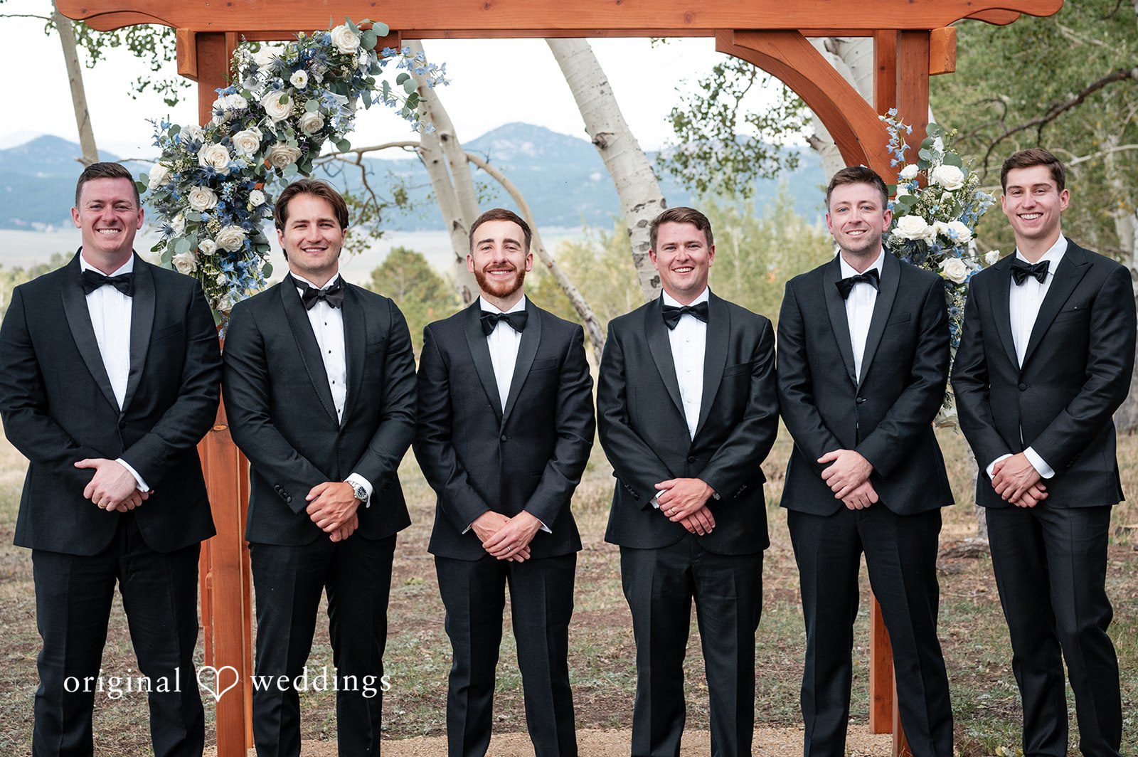 Erin + John Groom with his groomsmen at the ceremony arch