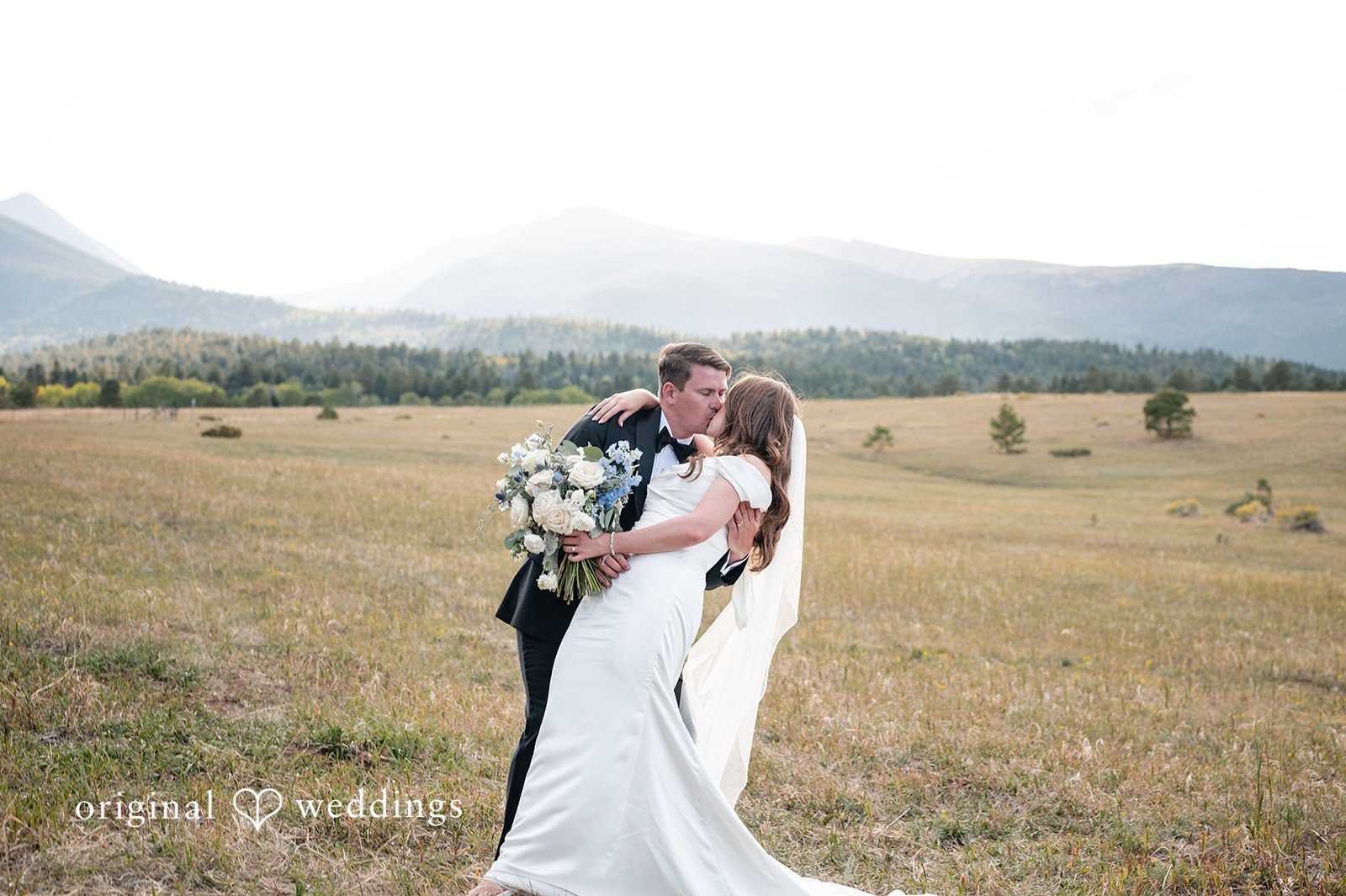 Erin + John Couple sharing a kiss with mountain views