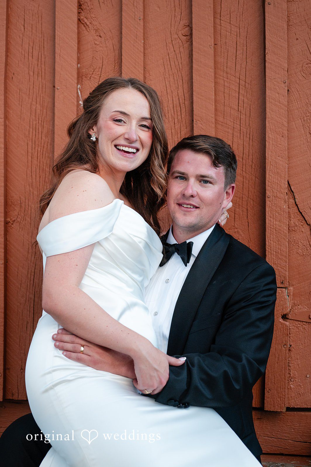 Erin + John Close portrait of the couple by the red barn wall