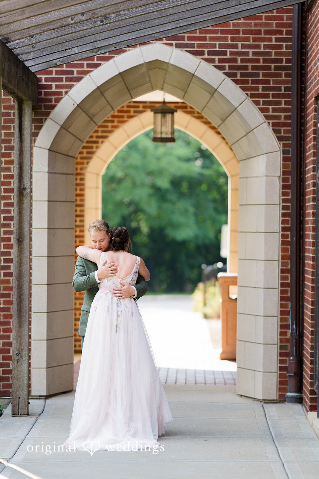 Griffin + Lauren Bride standing in the stone archway at Community House Winnetka