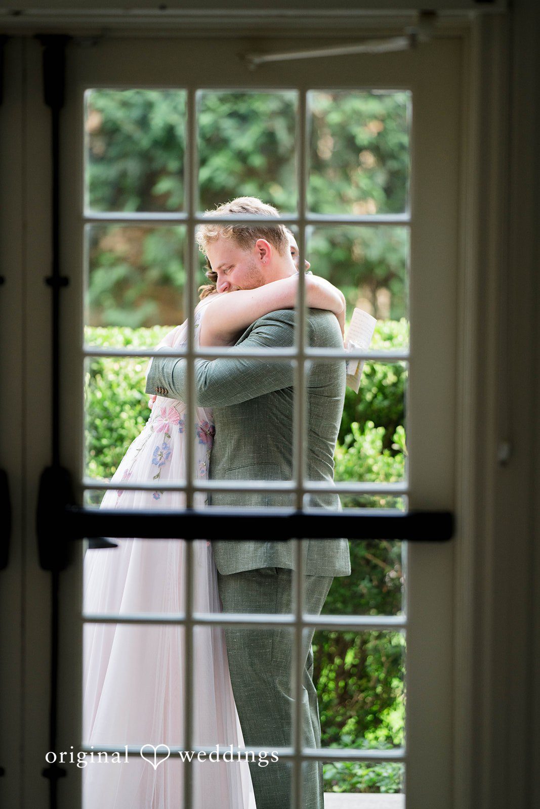 Griffin + Lauren Groom waiting behind a glass door