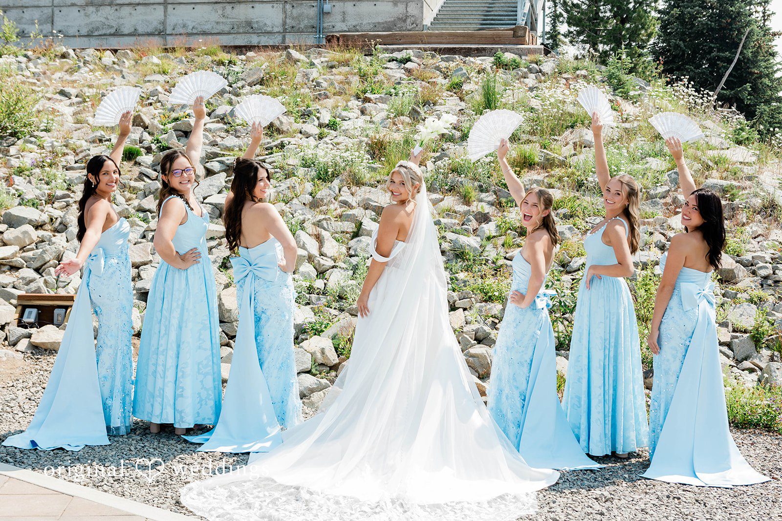 Bethany + Ryan A bride stands with her bridesmaids on a grassy mountain slope.