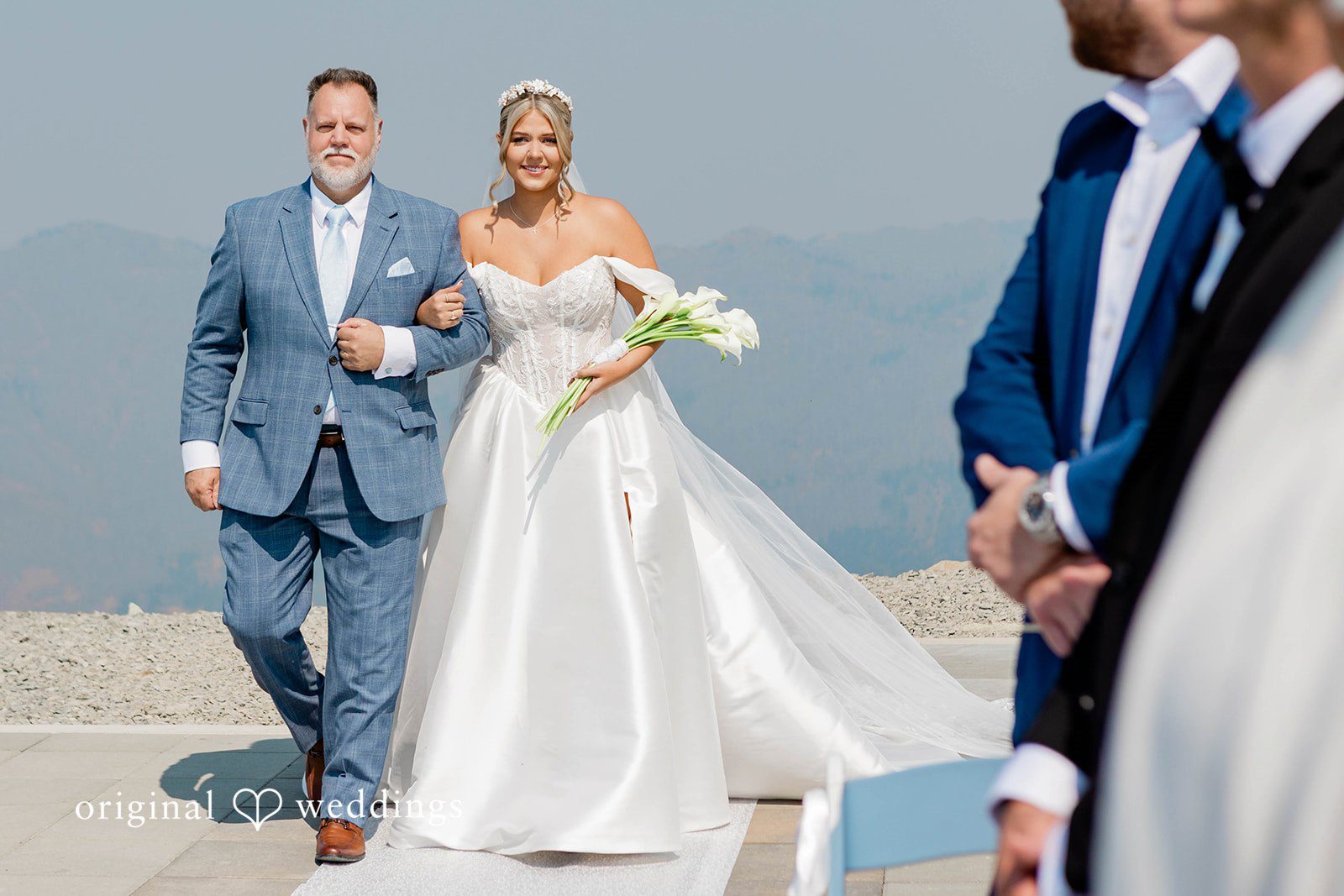 Bethany + Ryan A bride in a white gown and a man in a grey suit walk down the aisle.