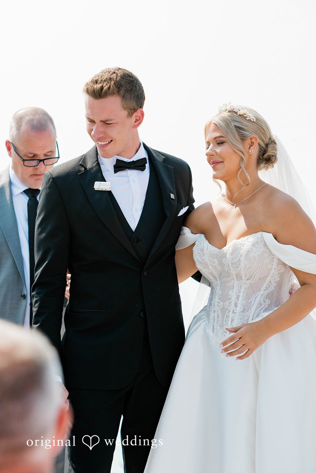 Bethany + Ryan A bride and groom smile at each other while standing at the altar.