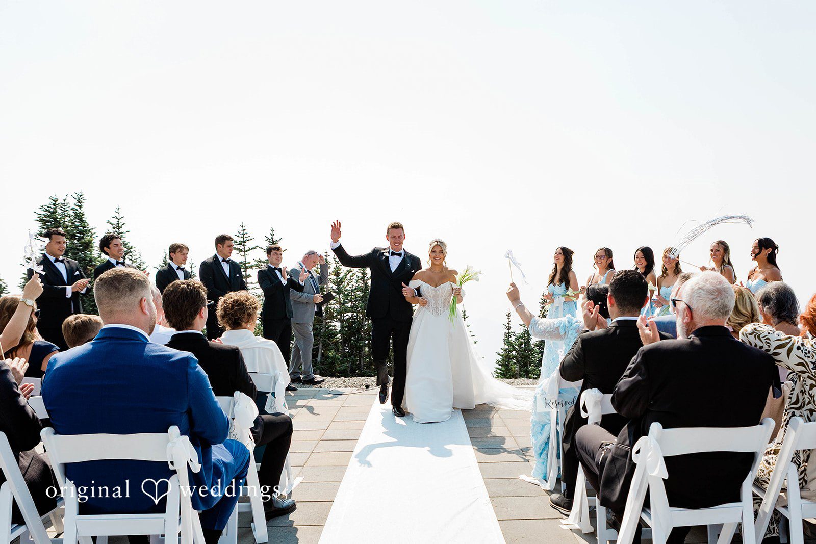 Bethany + Ryan A wide-angle view of a wedding ceremony taking place on an open mountain deck.