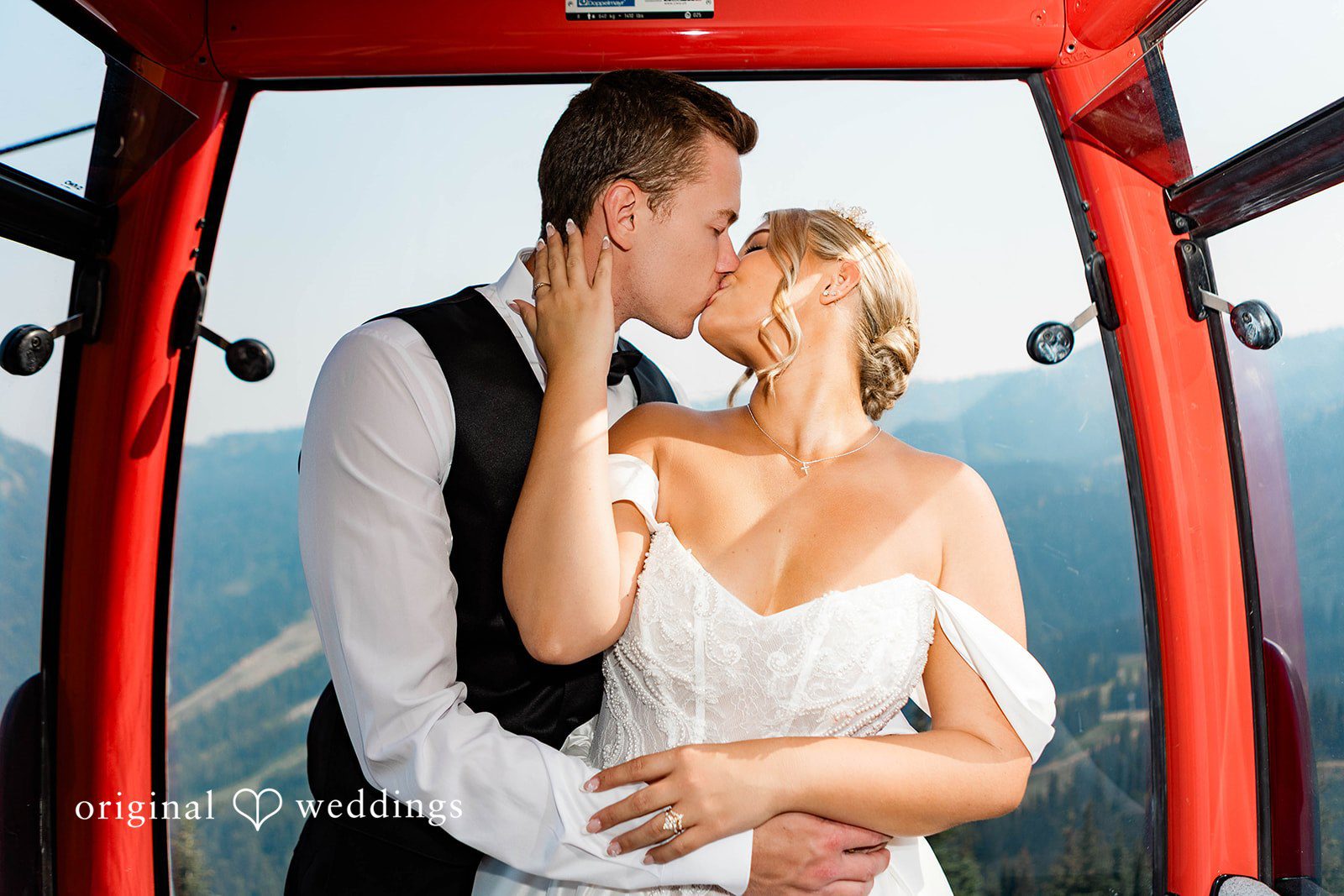 Bethany + Ryan A bride and groom share a close embrace inside a red mountain ski gondola.