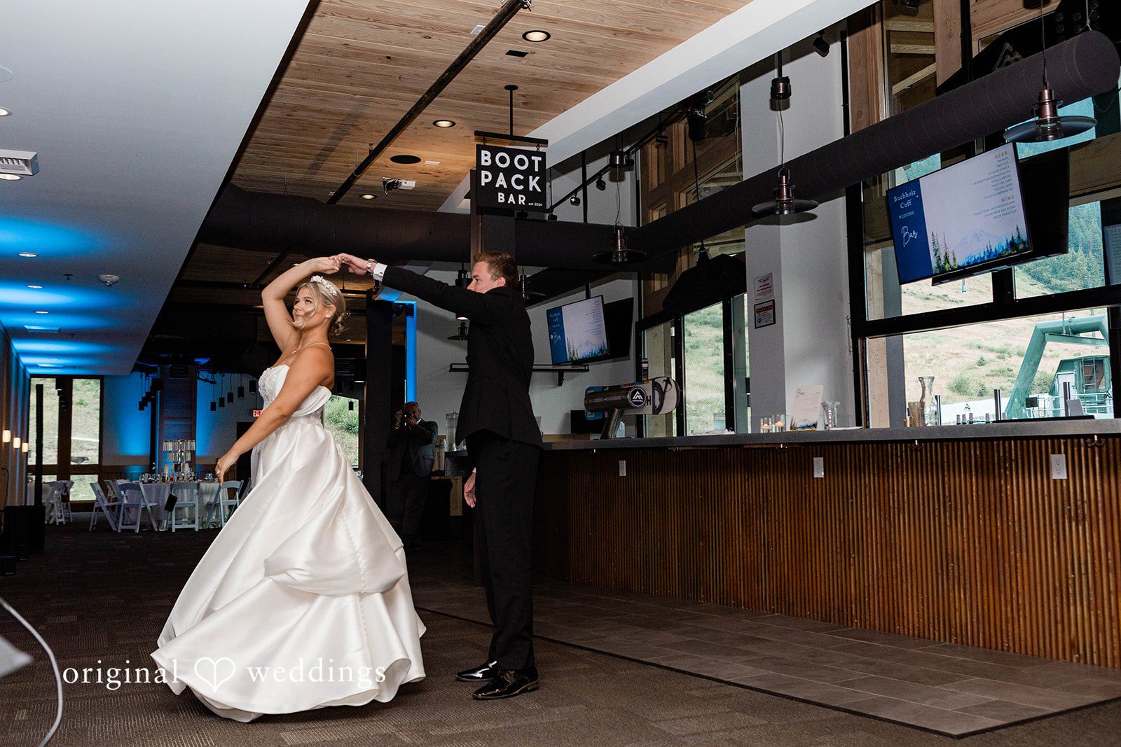 Bethany + Ryan A bride and groom share their first dance in a modern, dimly lit reception room.