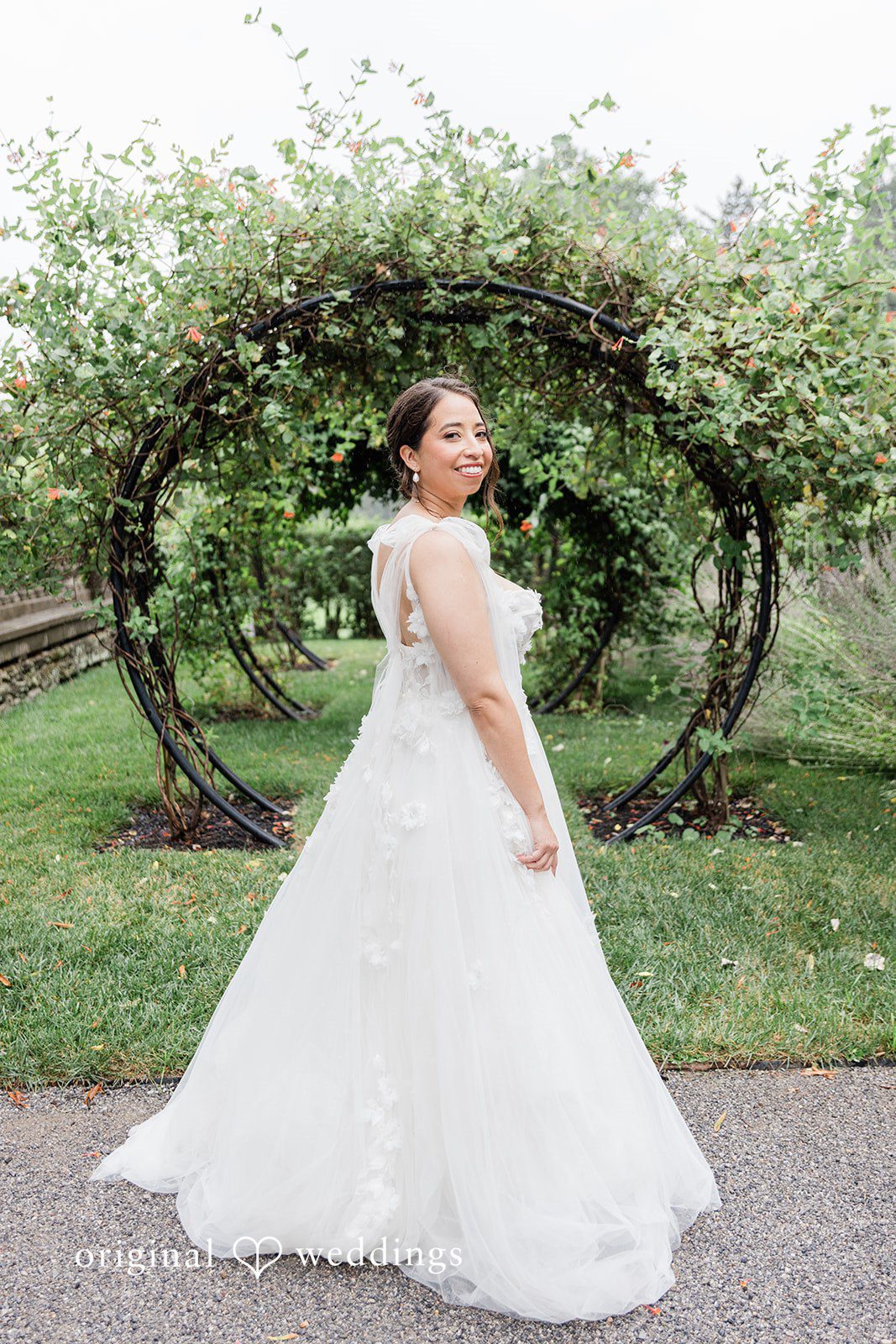 Bride standing in a garden archway at Curtis Arboretum