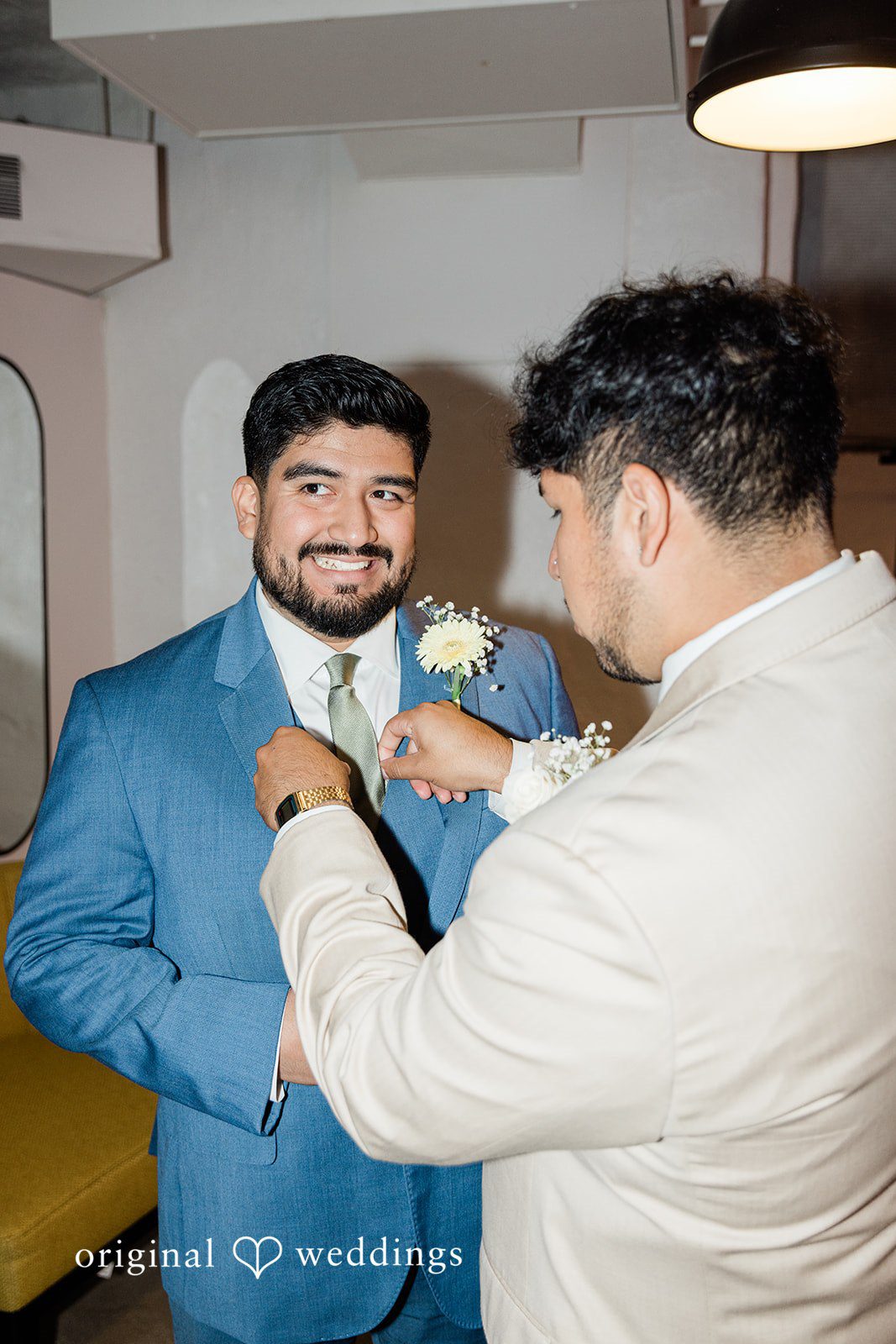 Groom getting help with his jacket