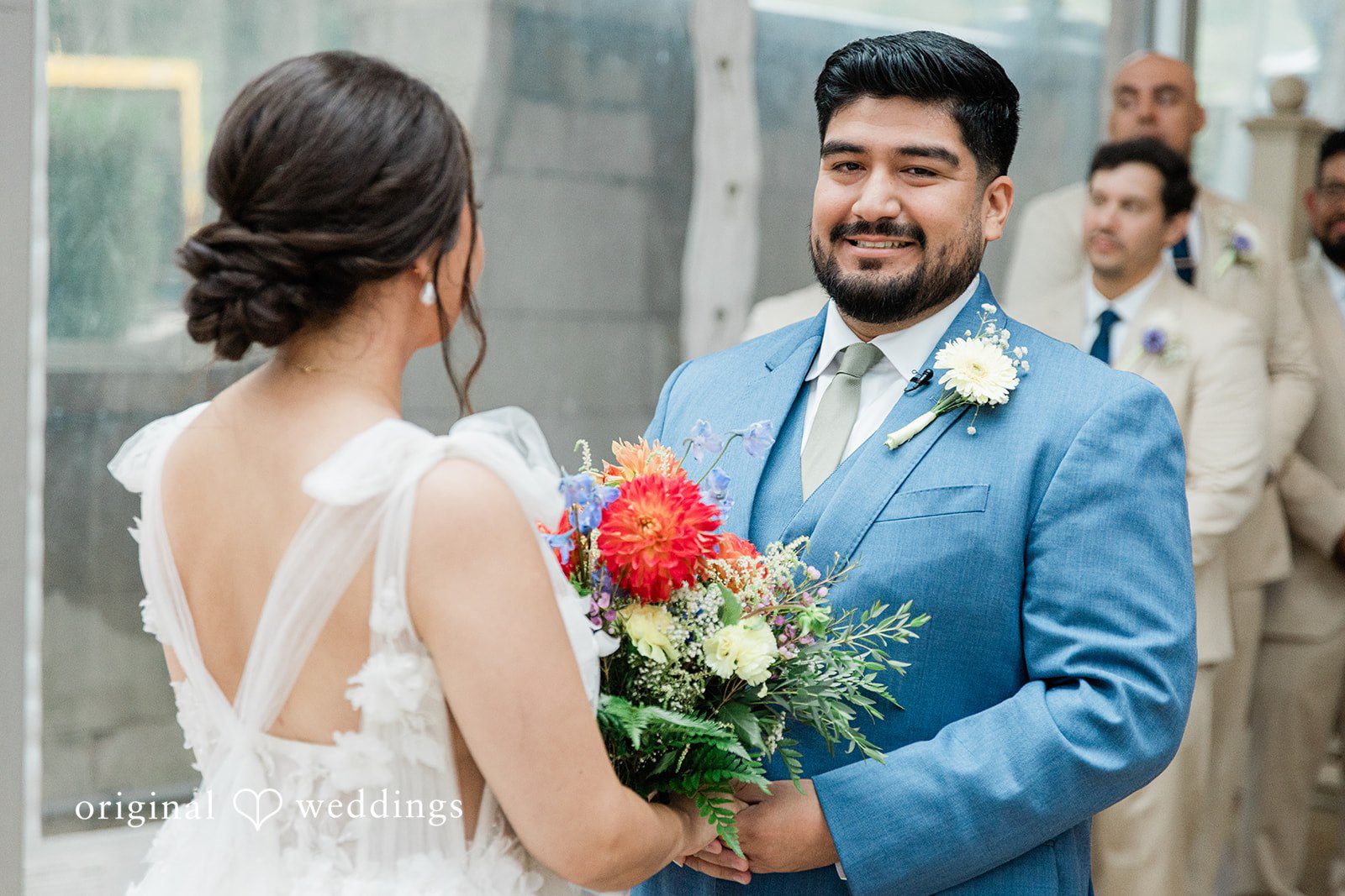 Couple close together with a bright bouquet