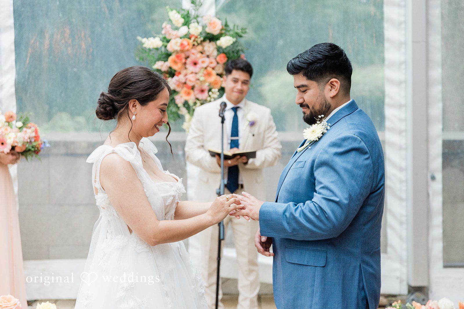 Couple exchanging rings under the floral arch