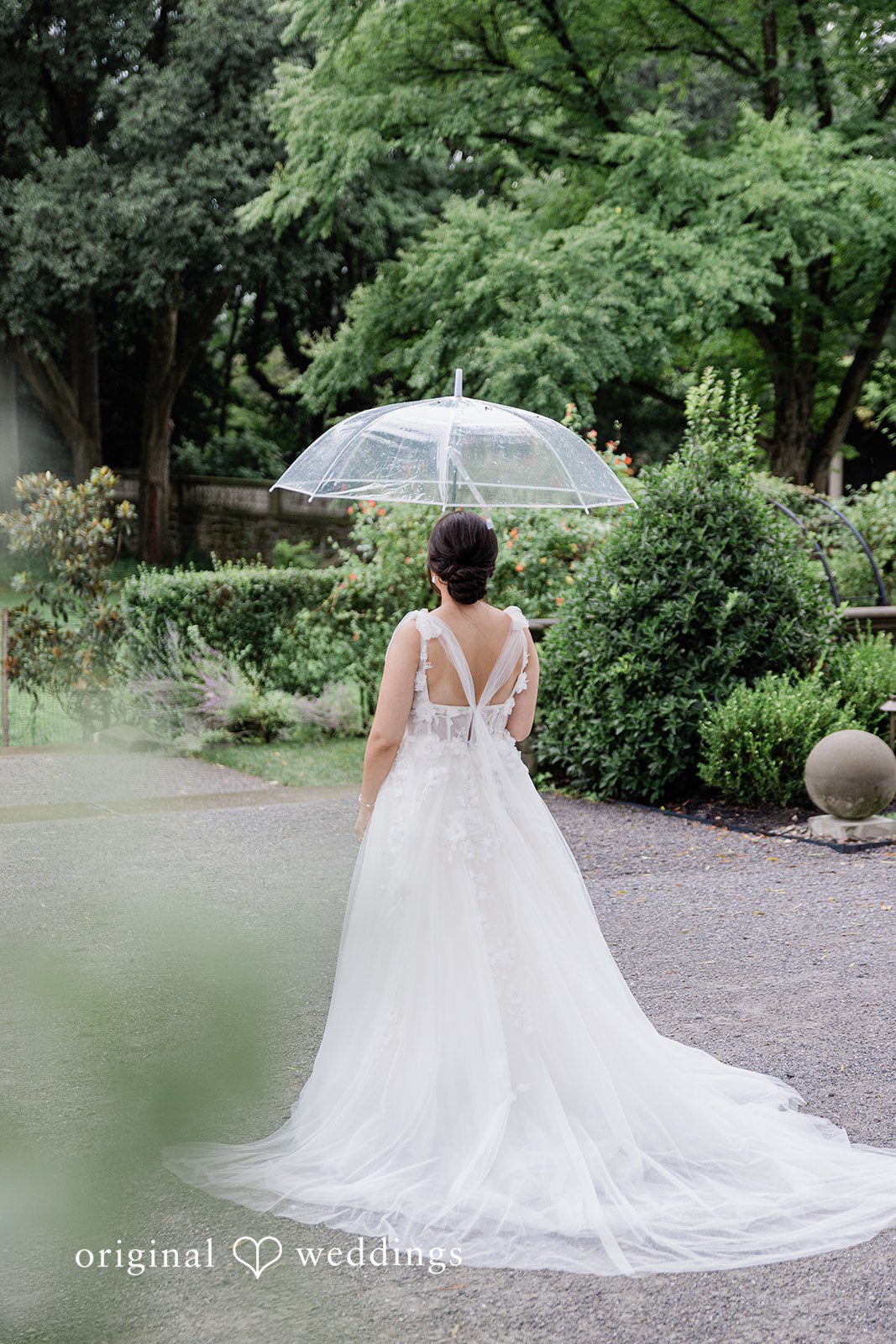 Bride walking with an umbrella among the trees