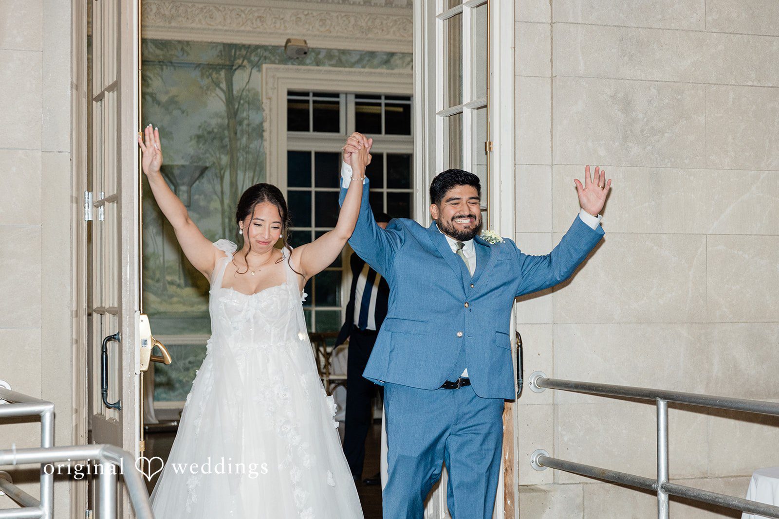 Couple cheering as they enter the reception