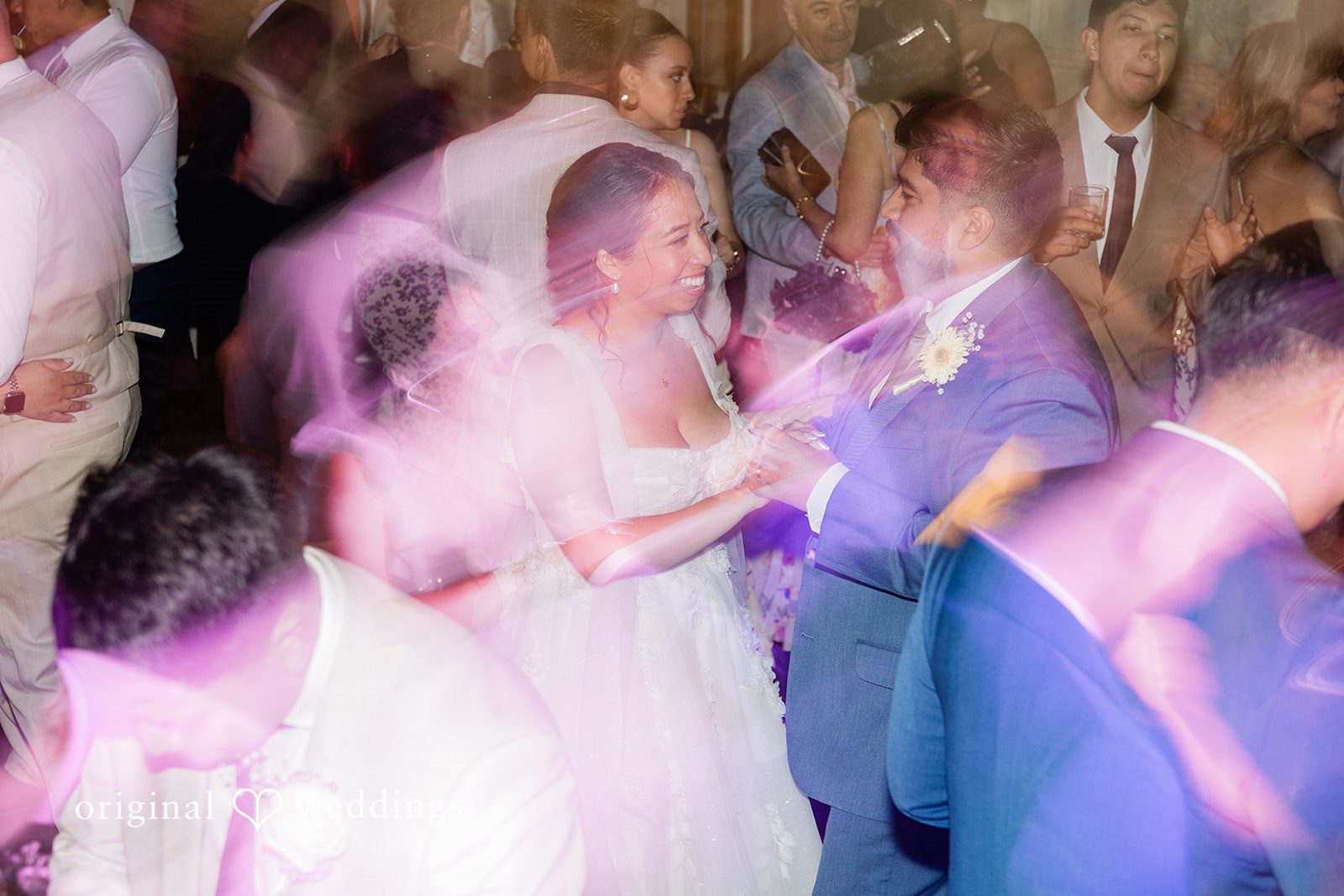 Guests dancing under colorful lights