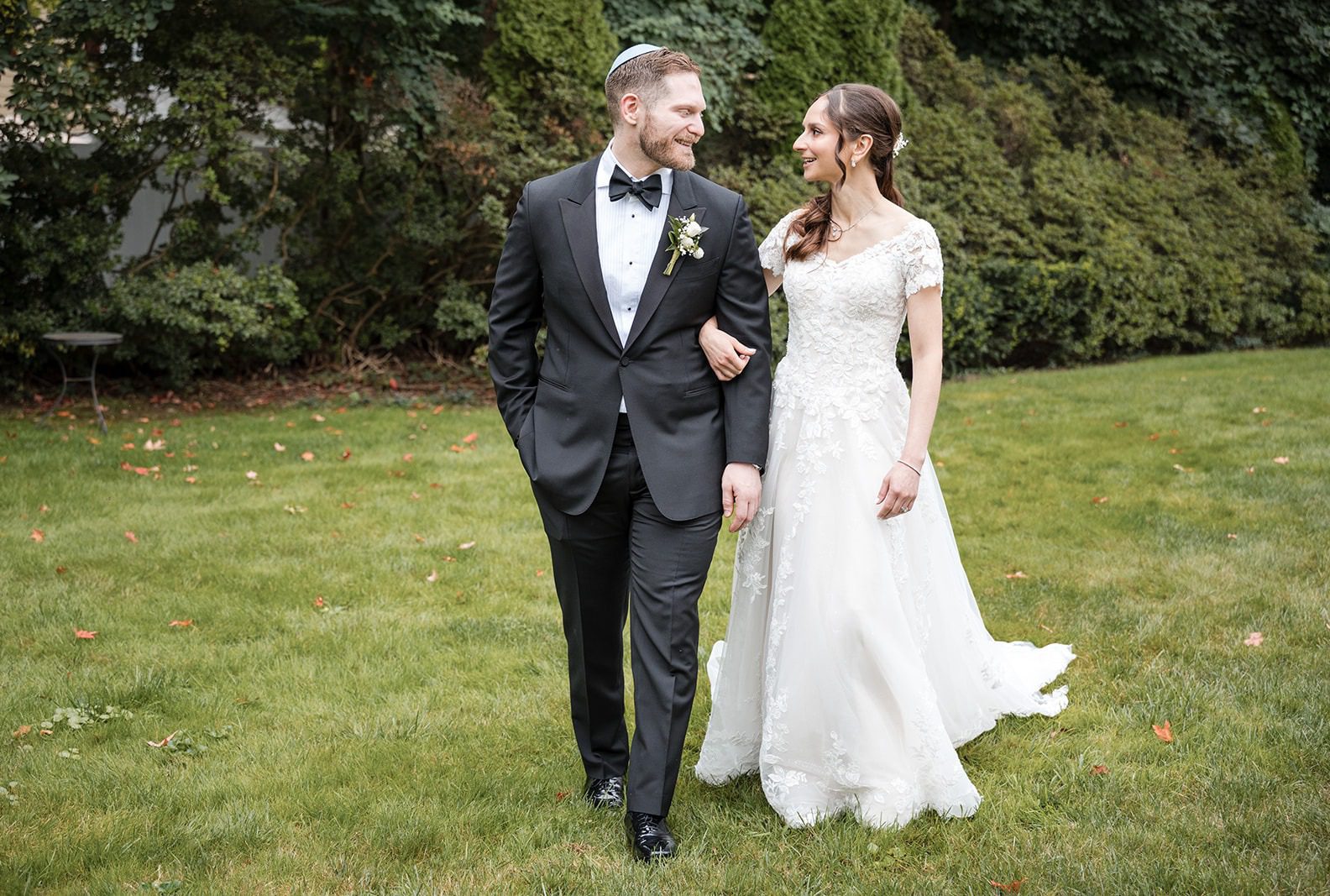 Jonathan and Arianna walking together across the lawn, captured by New York wedding photographers from Original Weddings at CV Rich Mansion