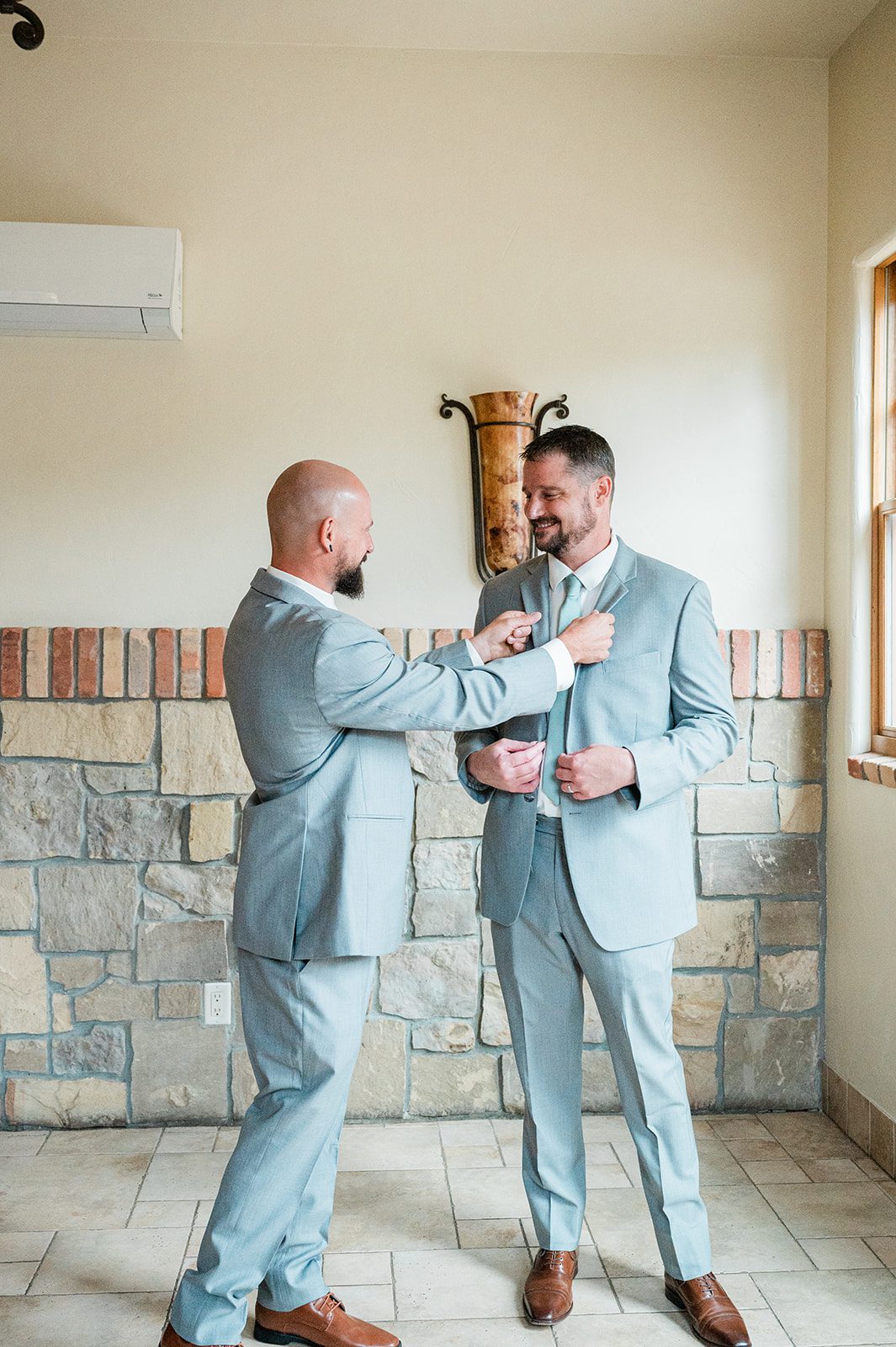 Groomsman helping the groom get ready