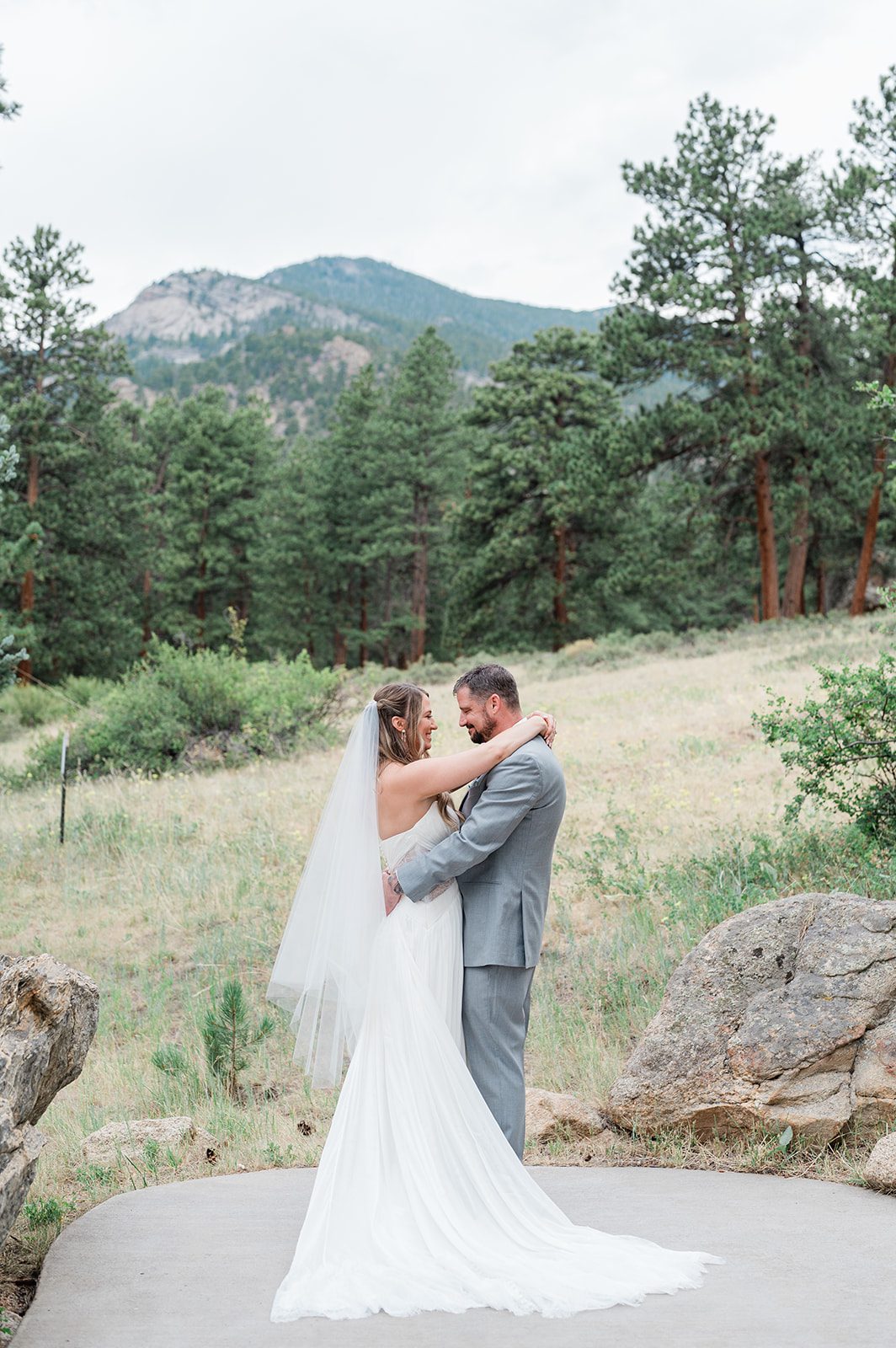 Bride and groom embracing in a mountain meadow