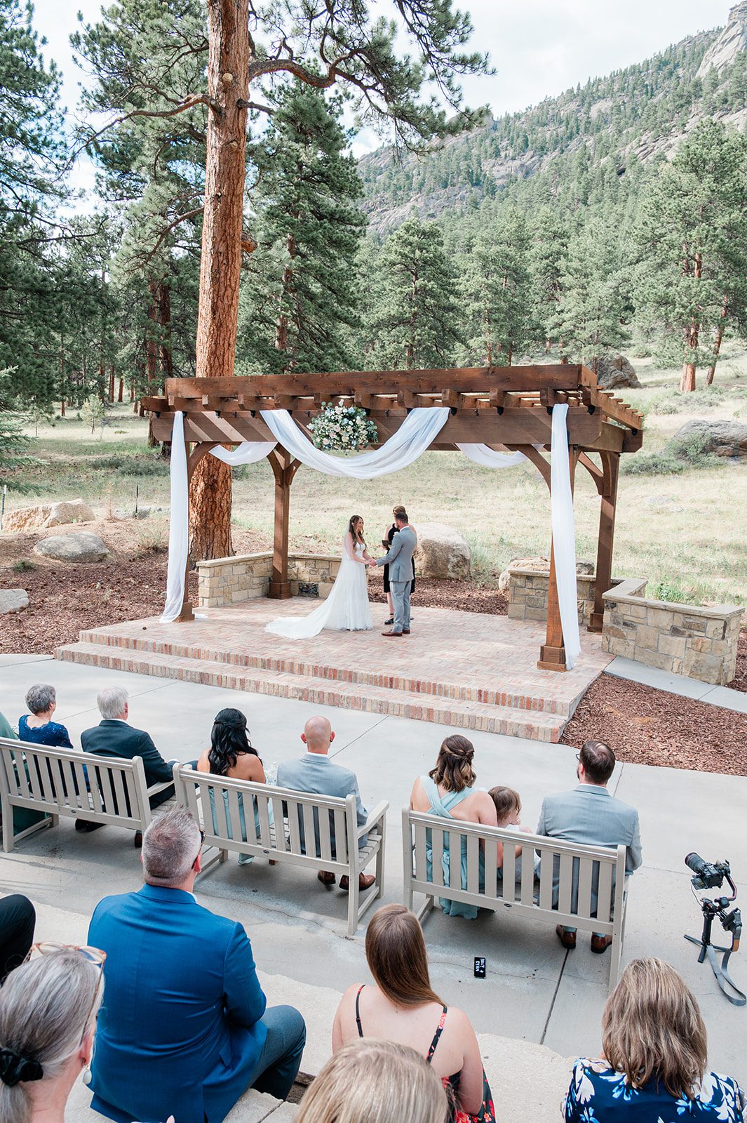 Guests watching the mountain ceremony under the wooden arbor at Della Terra Mountain Chateau