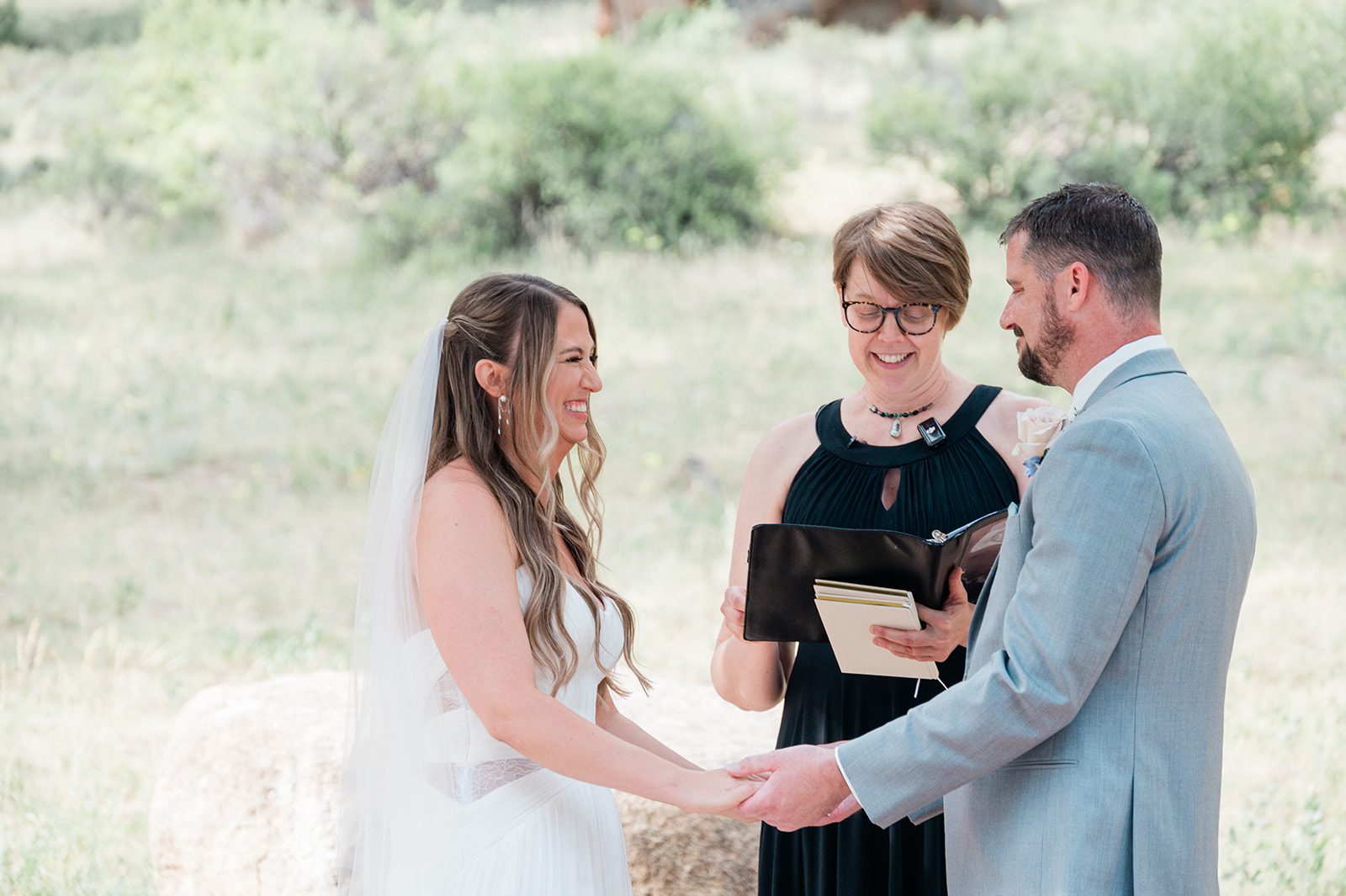 Bride and groom holding hands during their vows
