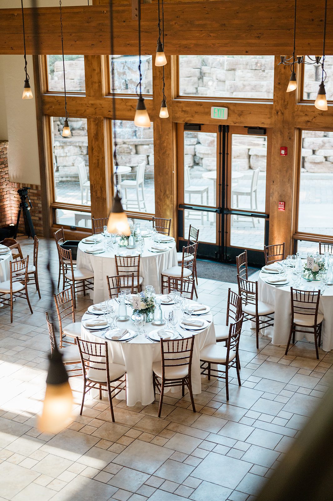 Reception room set with round tables and tall windows at Della Terra Mountain Chateau