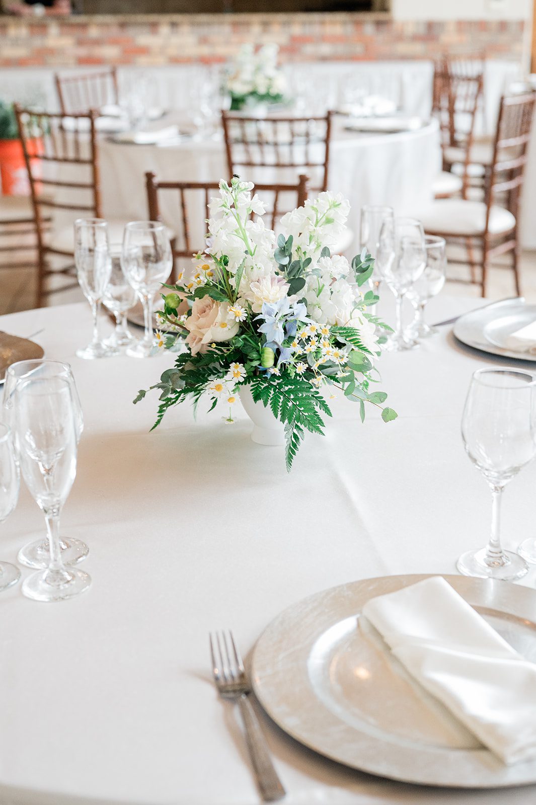 Reception table setting with white florals and greenery