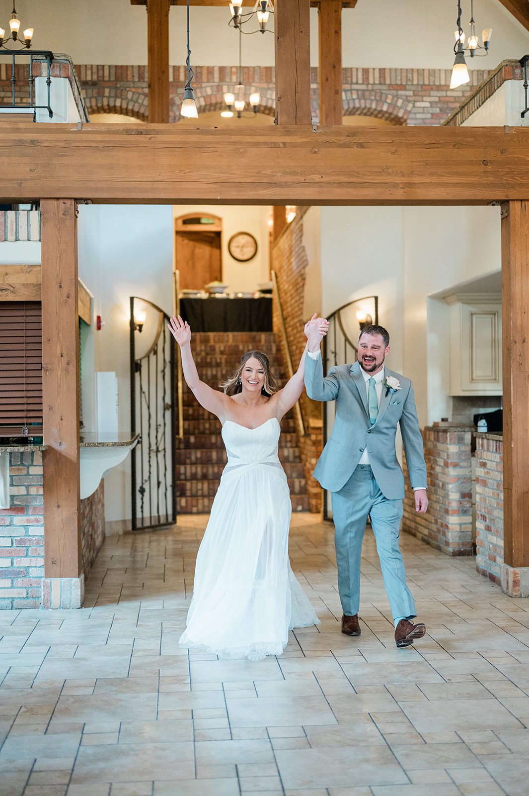 Bride and groom making a joyful grand entrance into the reception