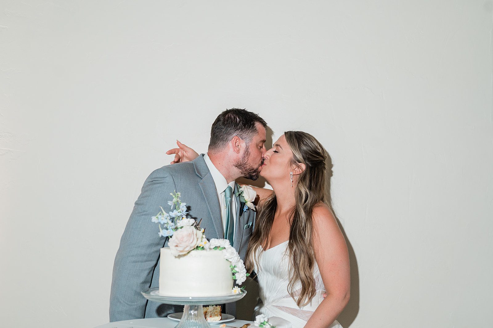 Couple sharing a kiss after cutting the cake