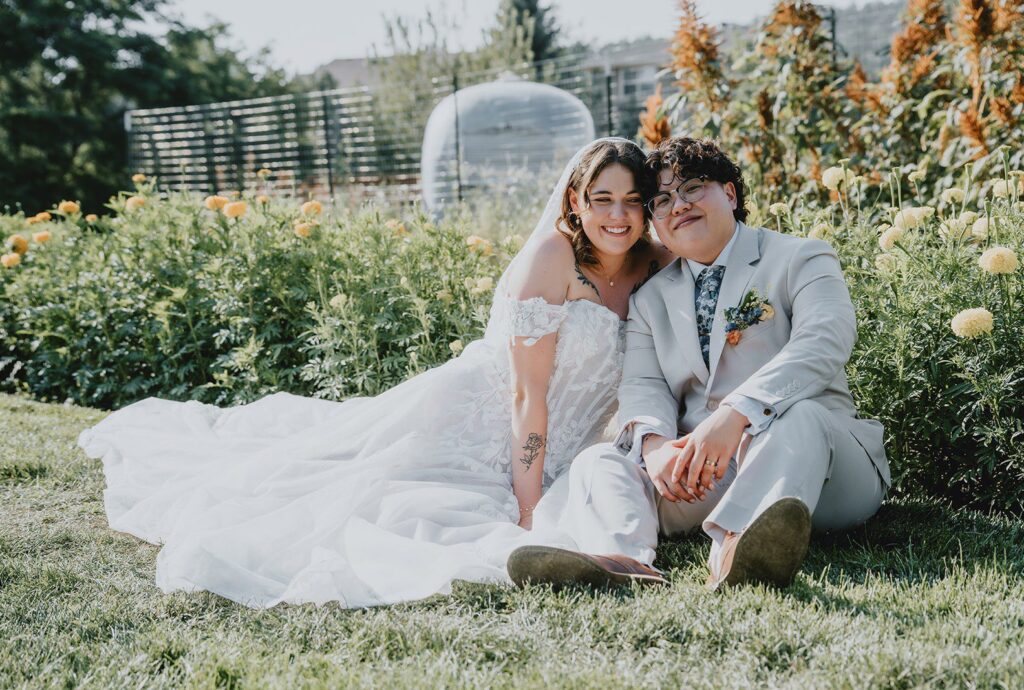 Denver Wedding Photographers at The Lyons Farmette | Alison & Kathy 10 Couple sitting together in the flower field, captured by Denver wedding photographers from Original Weddings at The Lyons Farmette