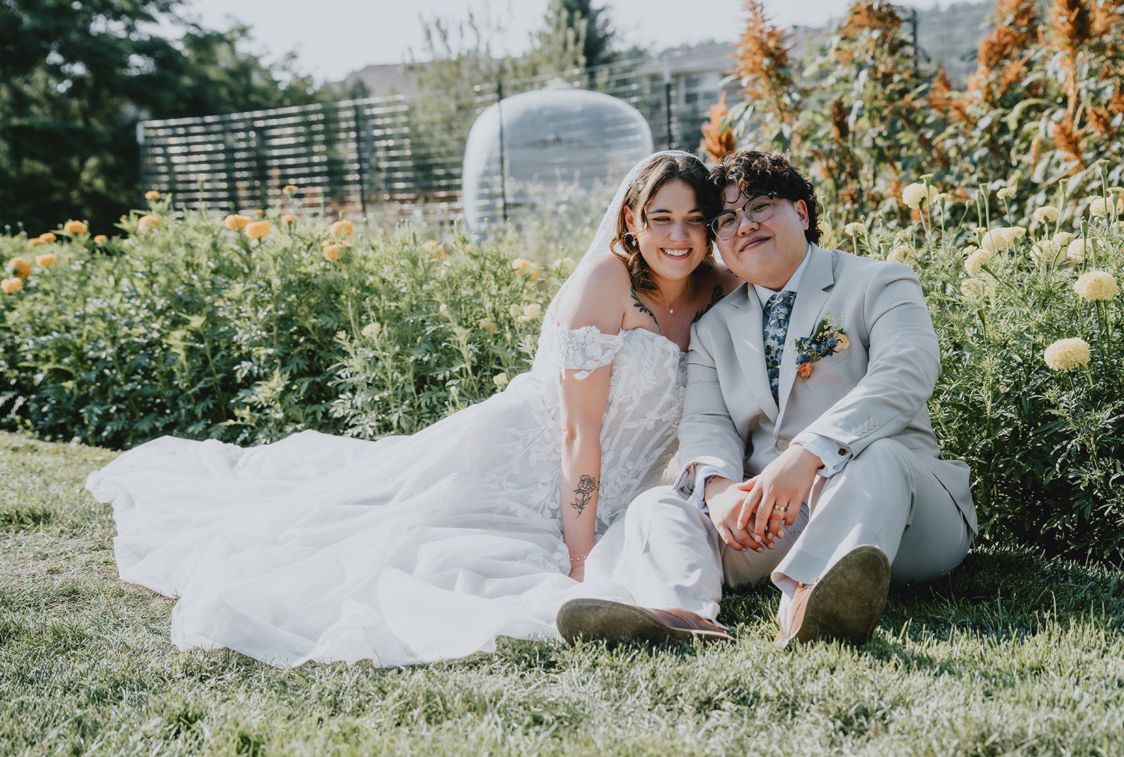Couple sitting together in the flower field, captured by Denver wedding photographers from Original Weddings at The Lyons Farmette