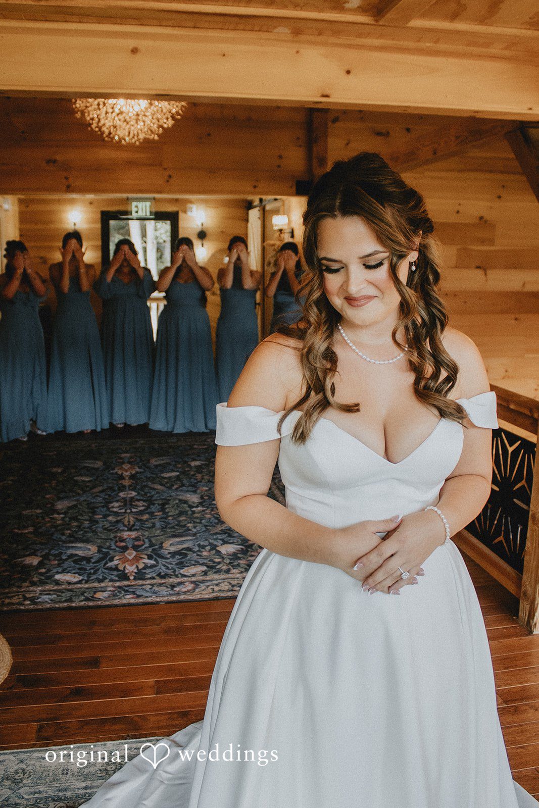 Sarah + Christopher A bride in a white gown looking towards the side inside a wooden building.