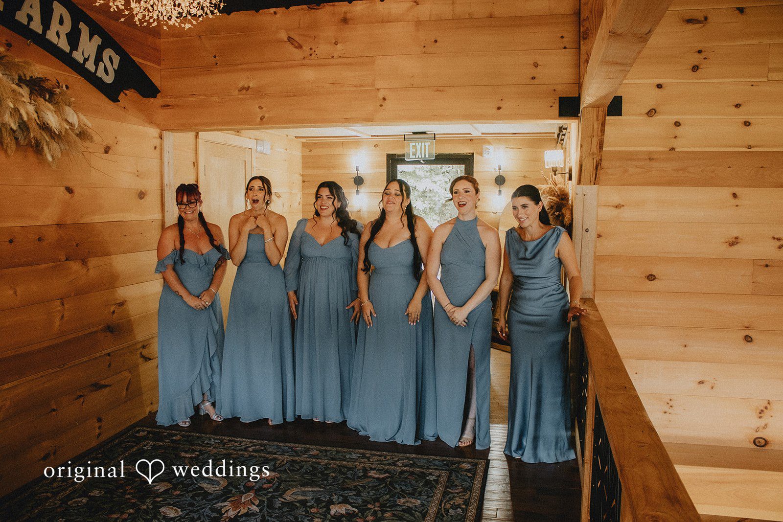 Sarah + Christopher Bridesmaids wearing matching light blue dresses lined up against a wall.