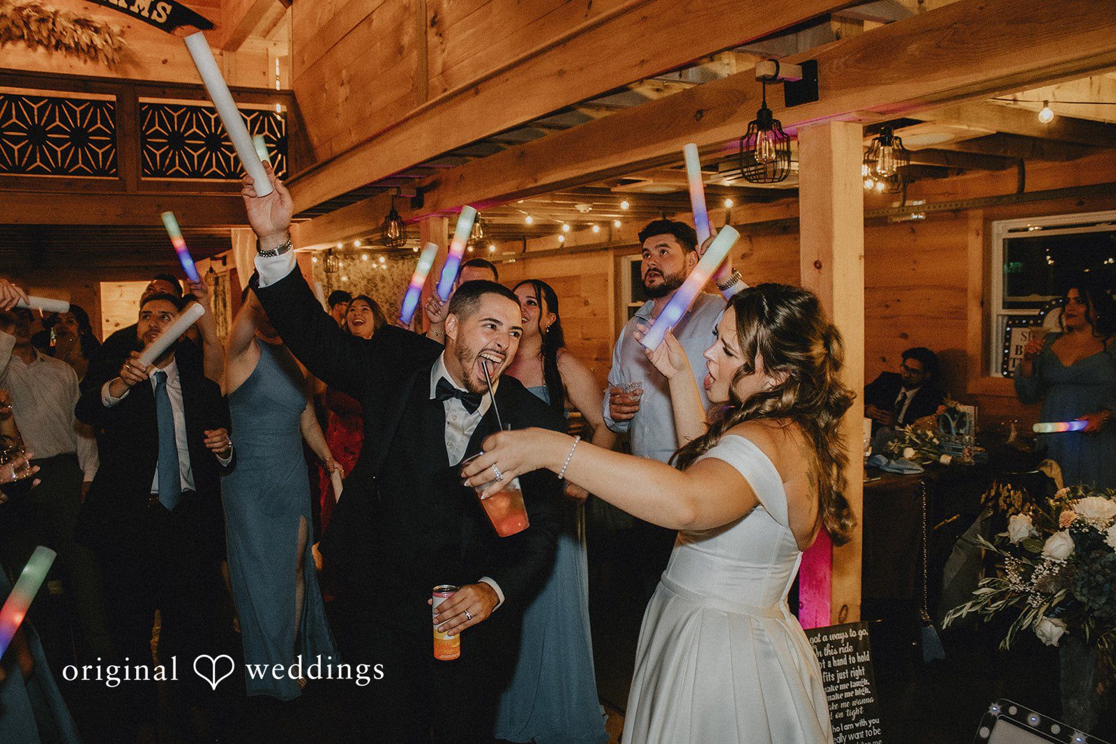 Sarah + Christopher A wedding party celebrating and raising their hands during a reception.