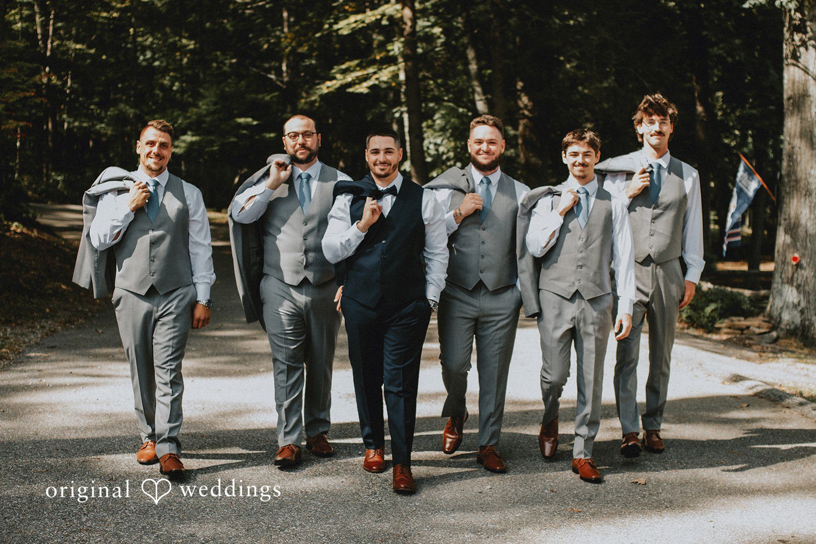 Sarah + Christopher Groomsmen wearing matching gray suits standing together in a line.