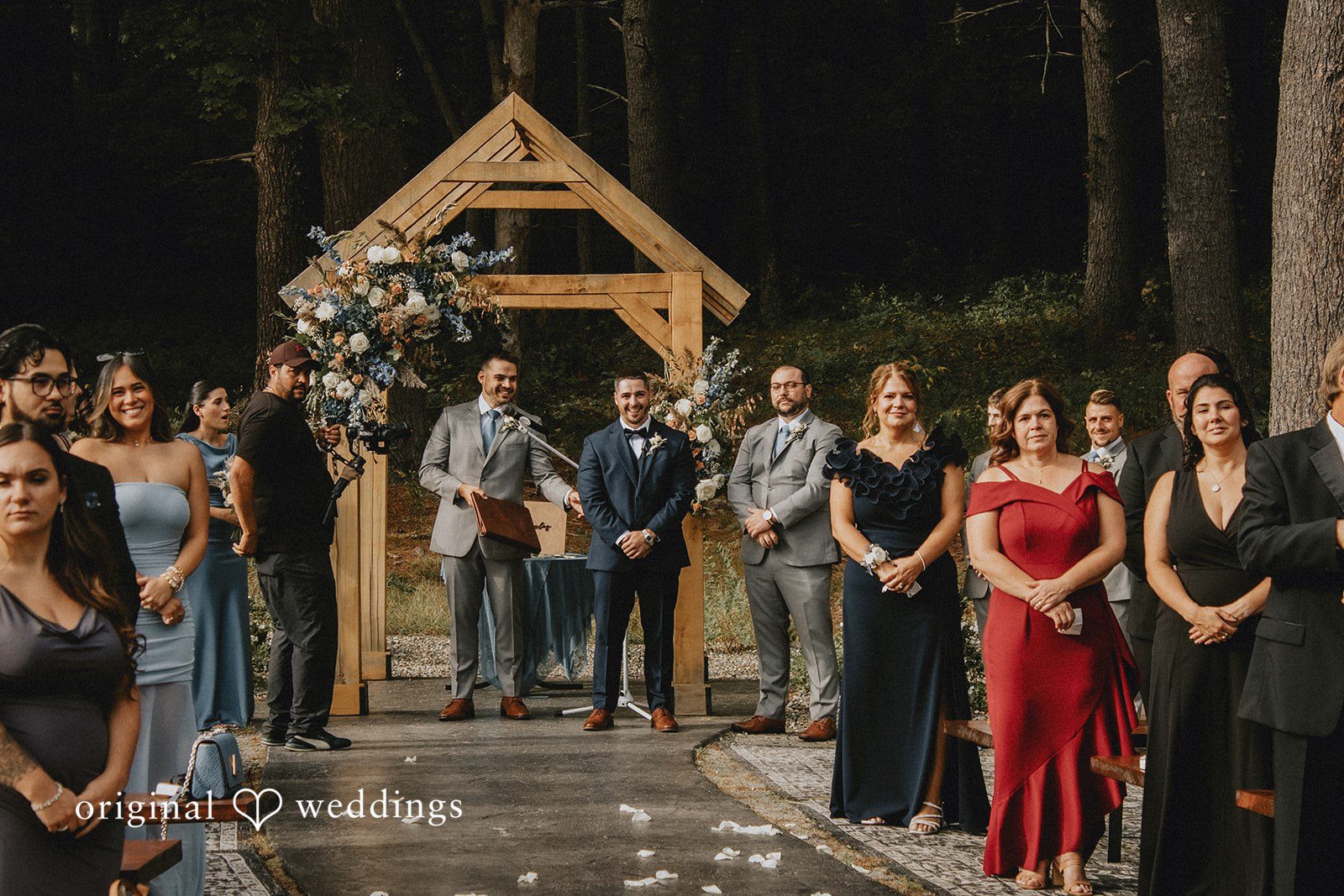 Sarah + Christopher Wedding guests dressed in formal attire standing in a row inside a venue.