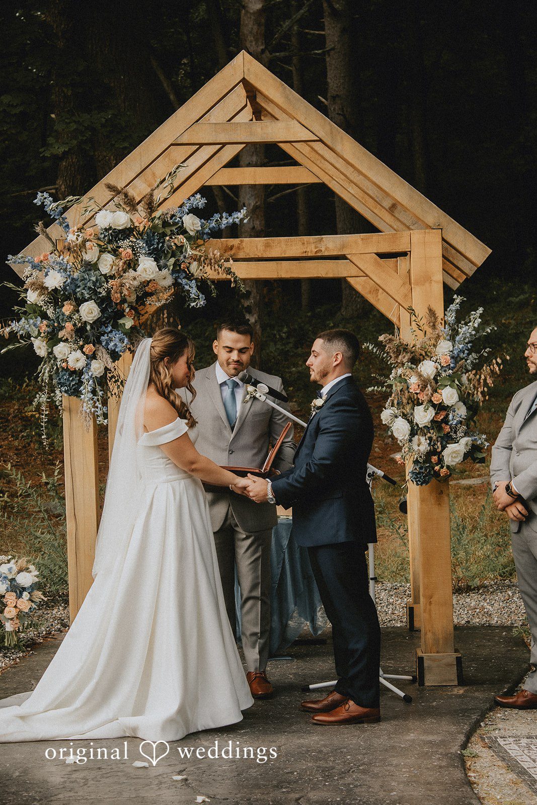 Sarah + Christopher A bride and groom standing before a wooden altar structure during the ceremony.