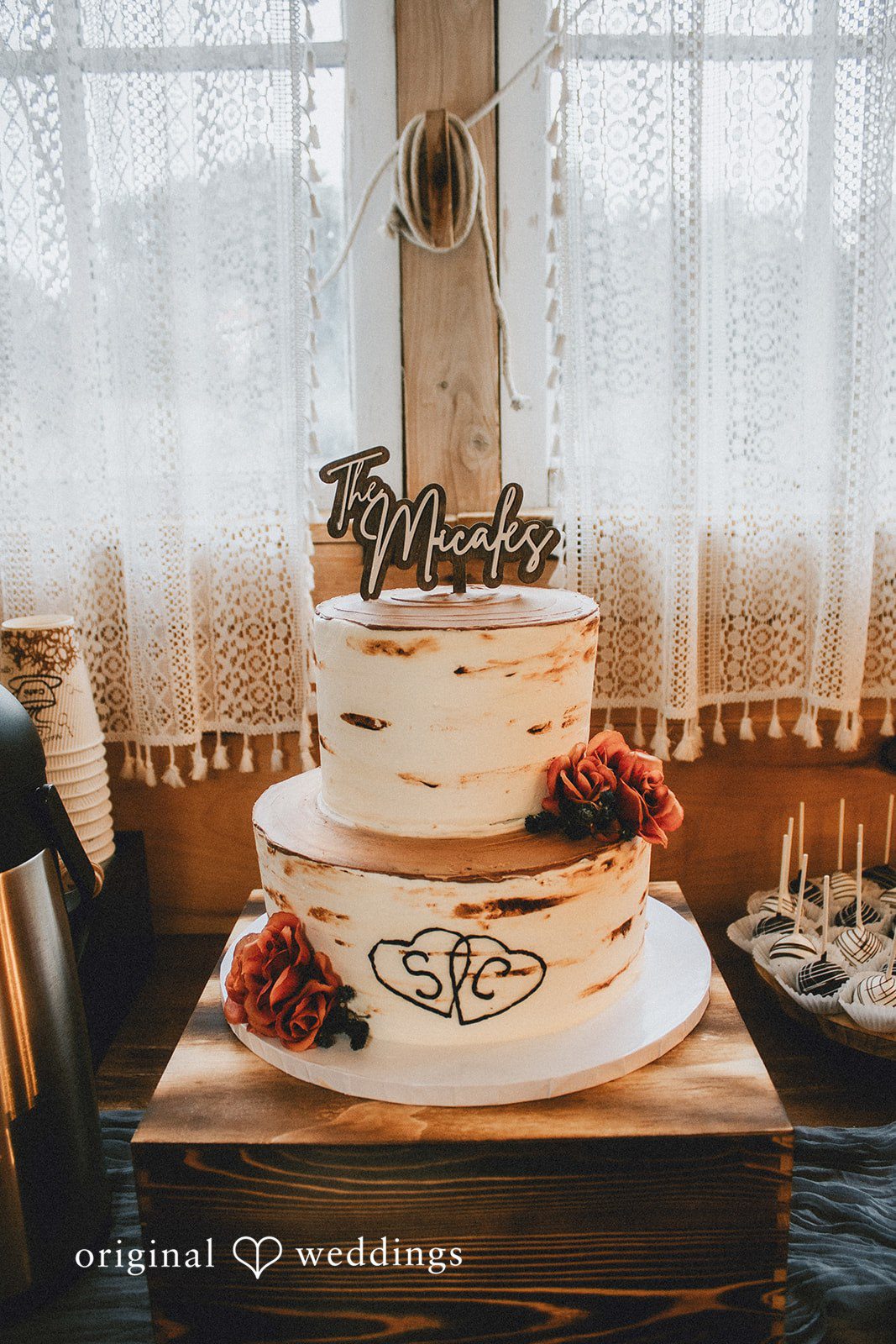 September 19, 2026 – Sarah & Christopher – (ID-4569) A three-tiered white wedding cake decorated with flowers on a wooden table.
