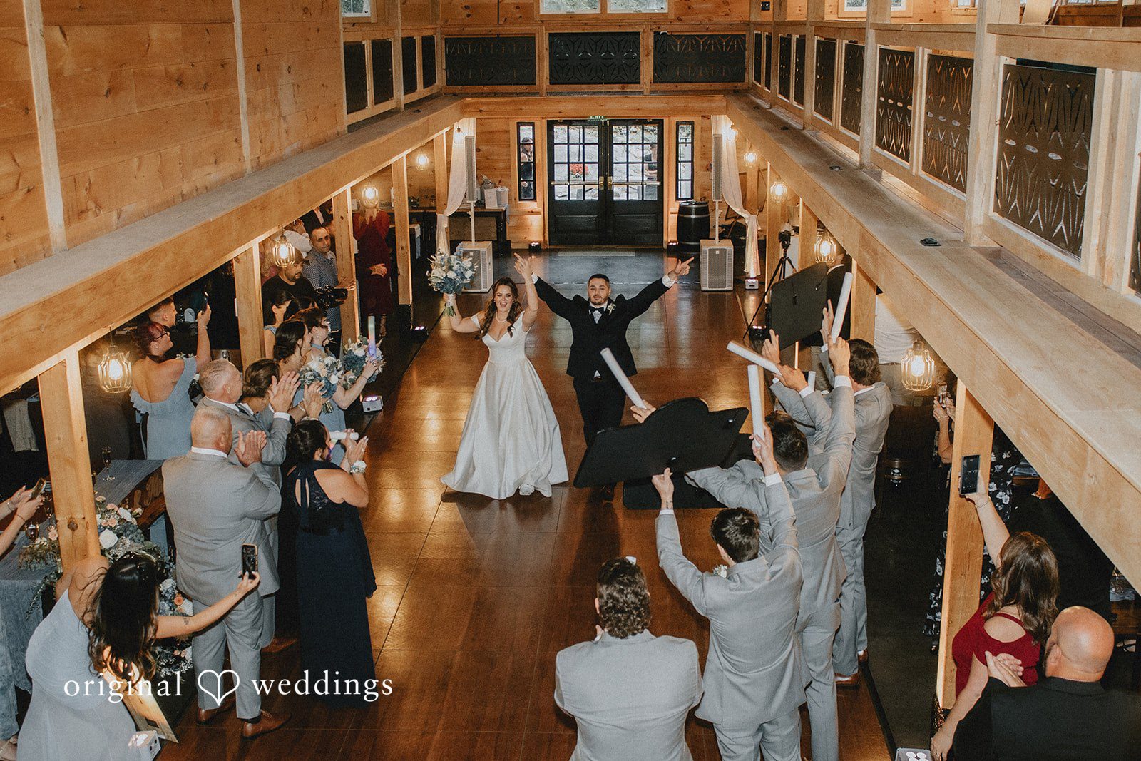 Sarah + Christopher An elevated view of a wedding reception inside a spacious wooden hall.