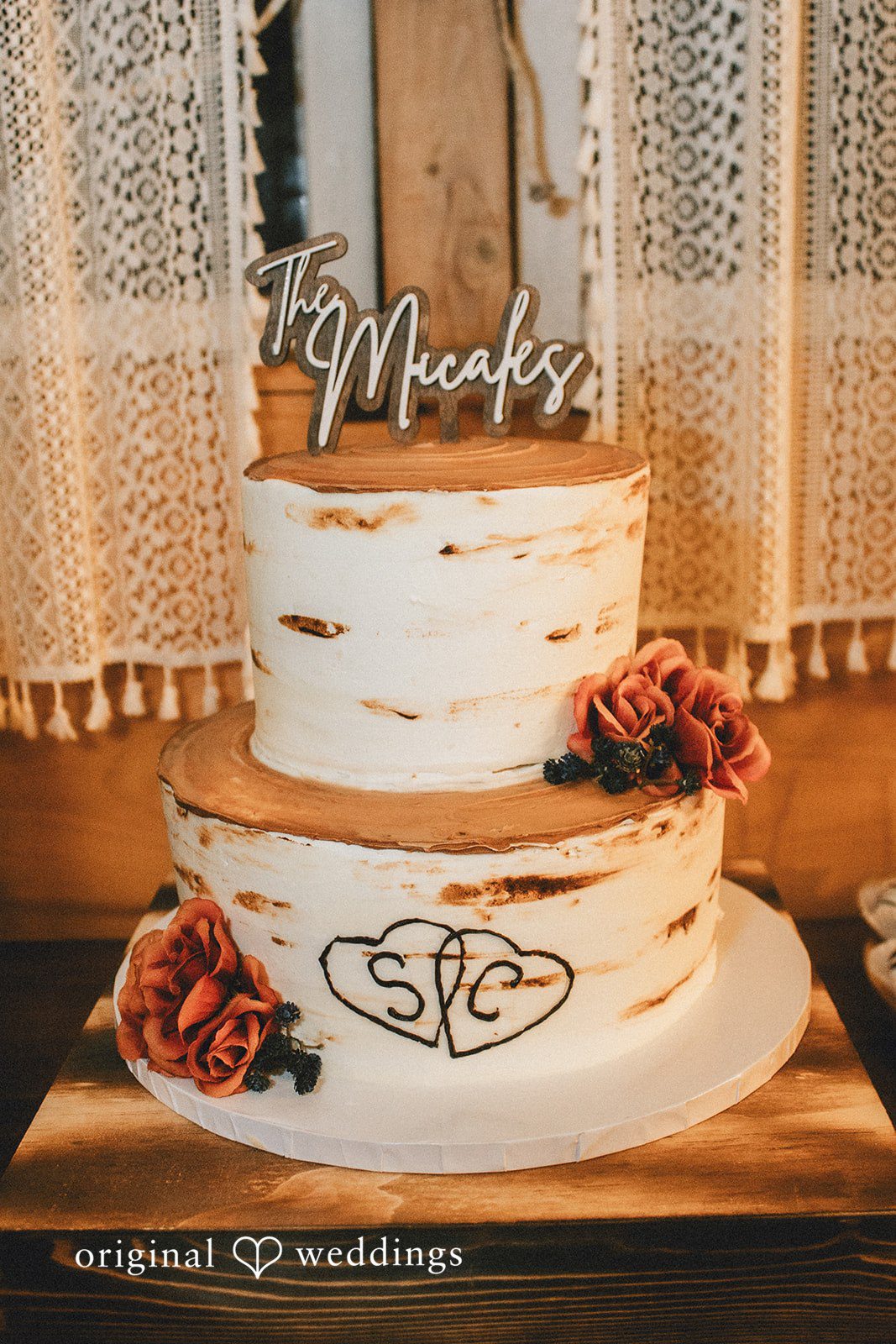 September 19, 2026 – Sarah & Christopher – (ID-4569) A three-tiered white frosted cake standing on a round wooden slice base.