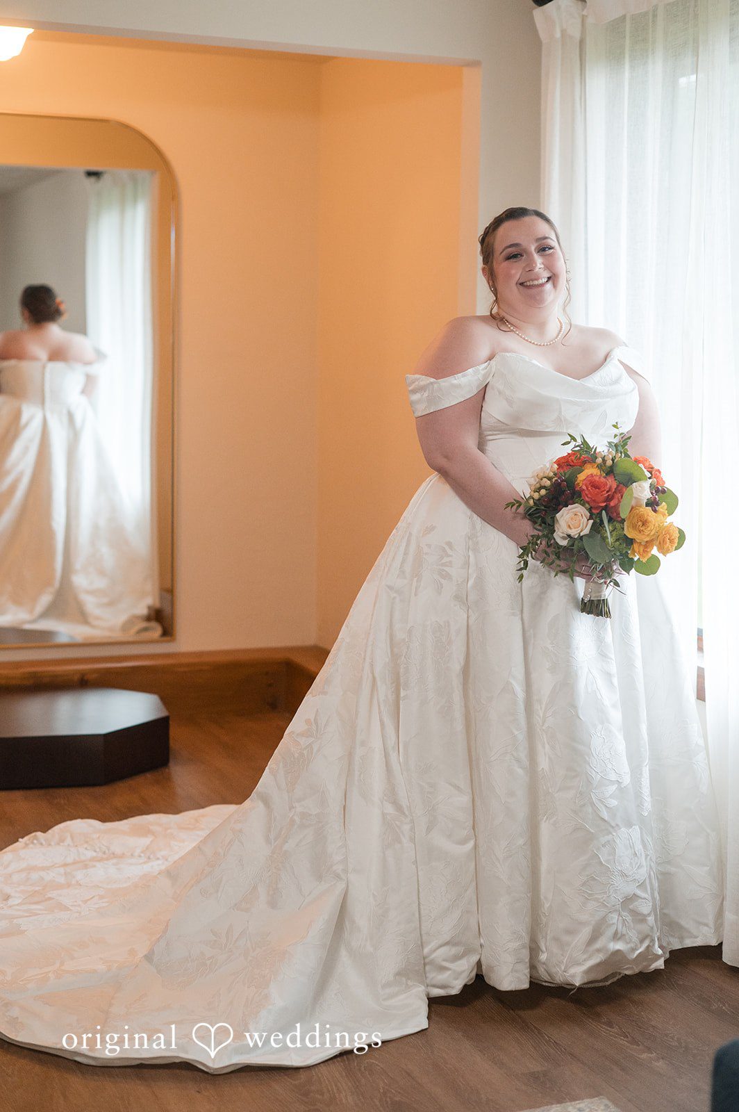 Marian in her gown holding a fall bouquet at Fern Hill Barn