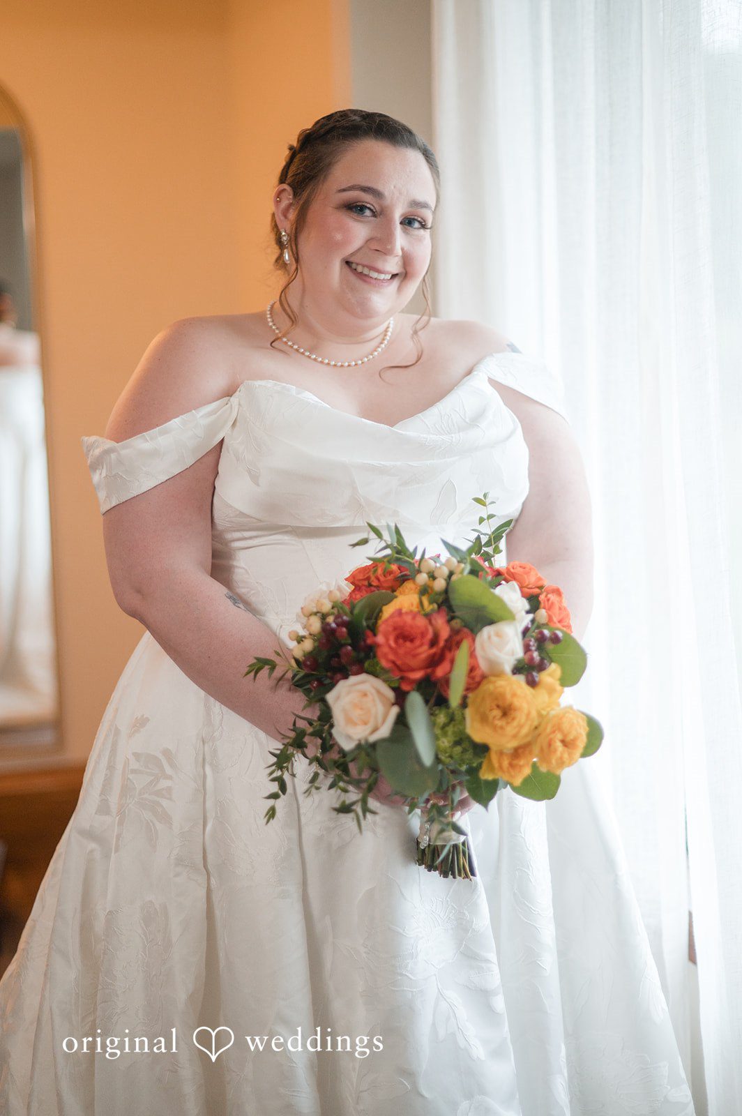 Marian smiling with her bouquet by the window