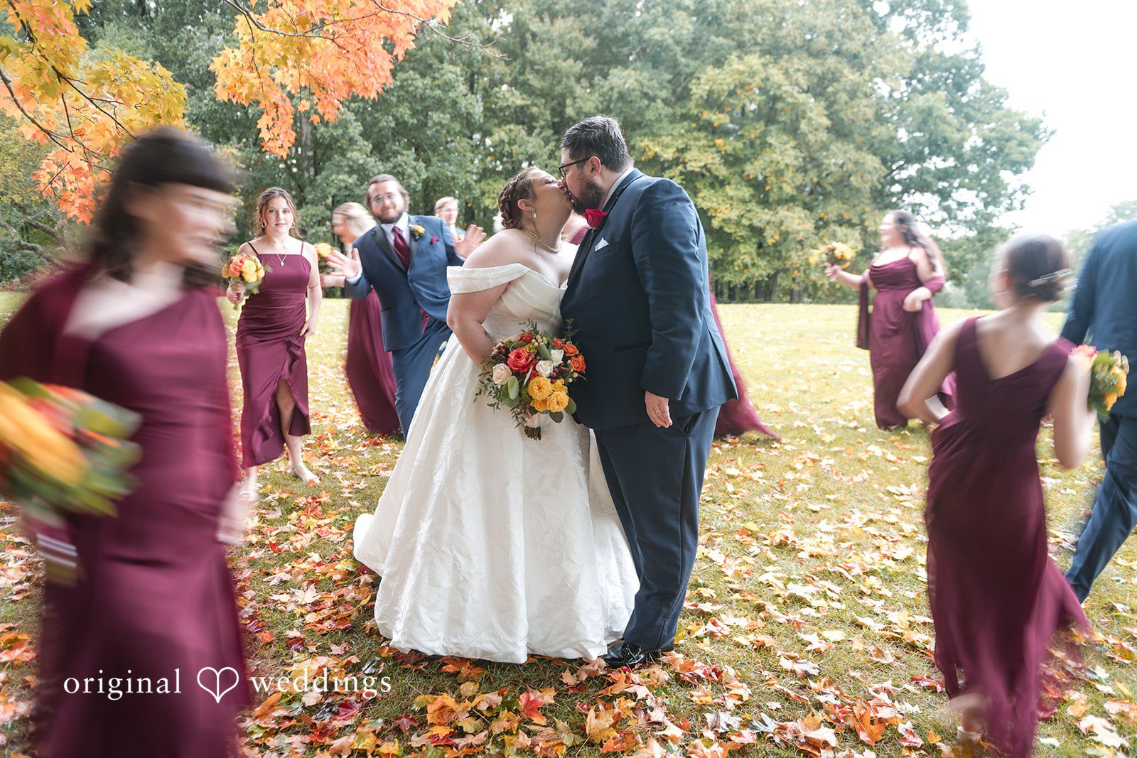 Andrew and Marian with their wedding party under fall trees at Fern Hill Barn
