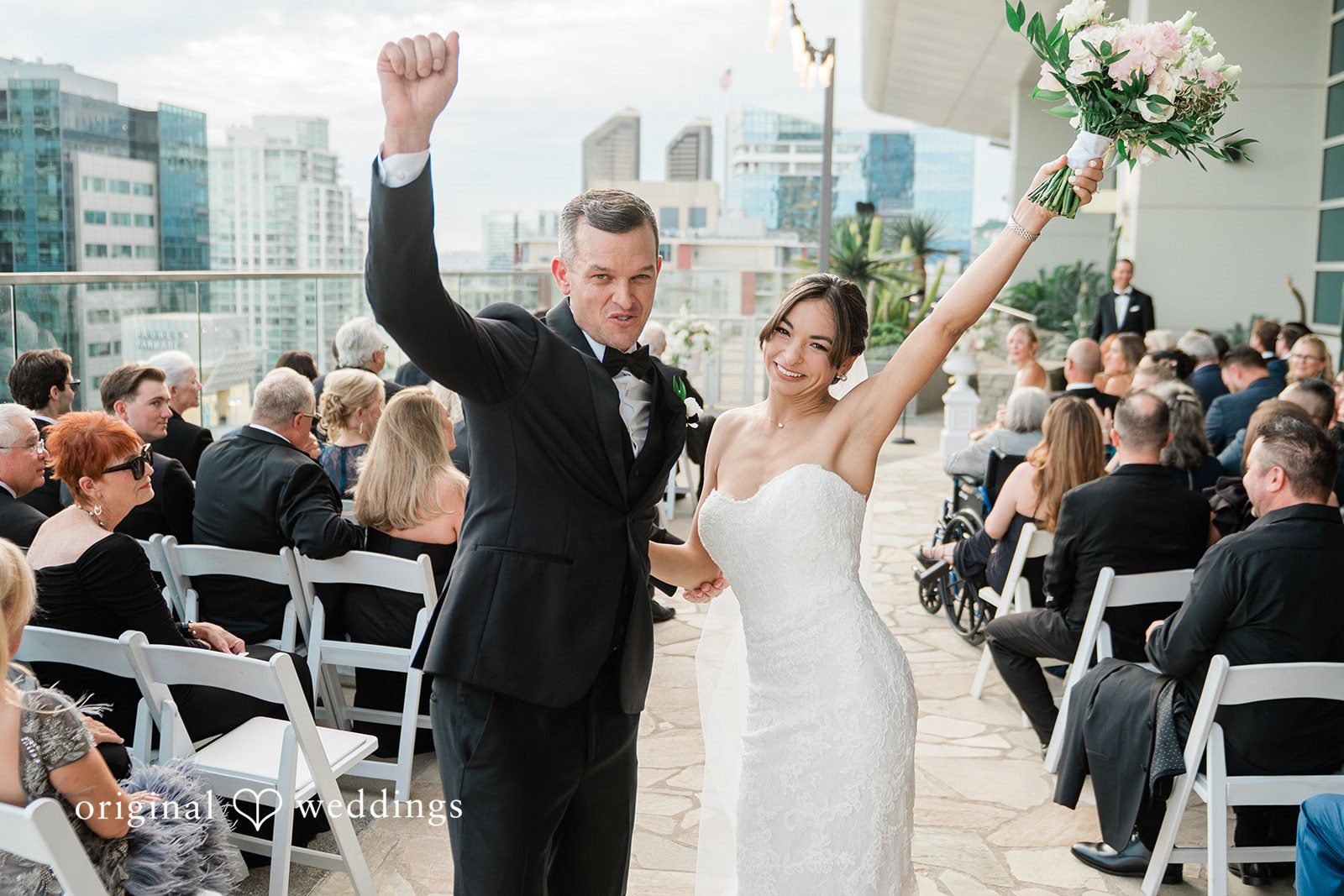 Groom cheering as the newlyweds walk back up the aisle