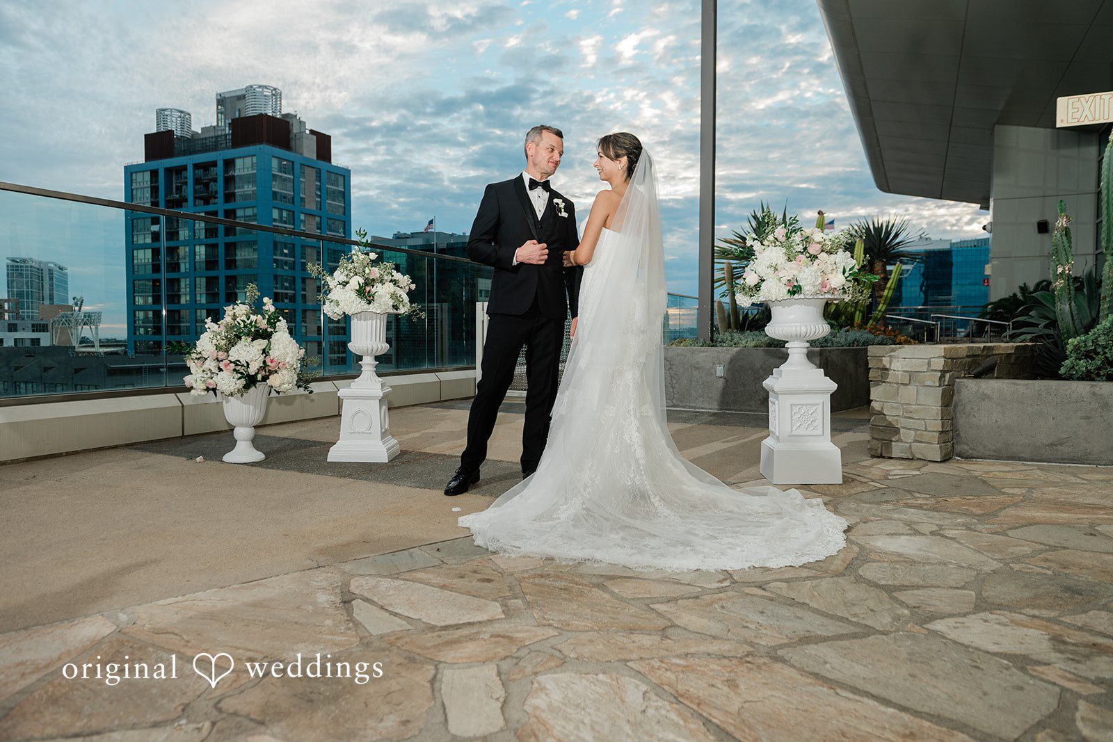 Couple standing at the floral ceremony arch
