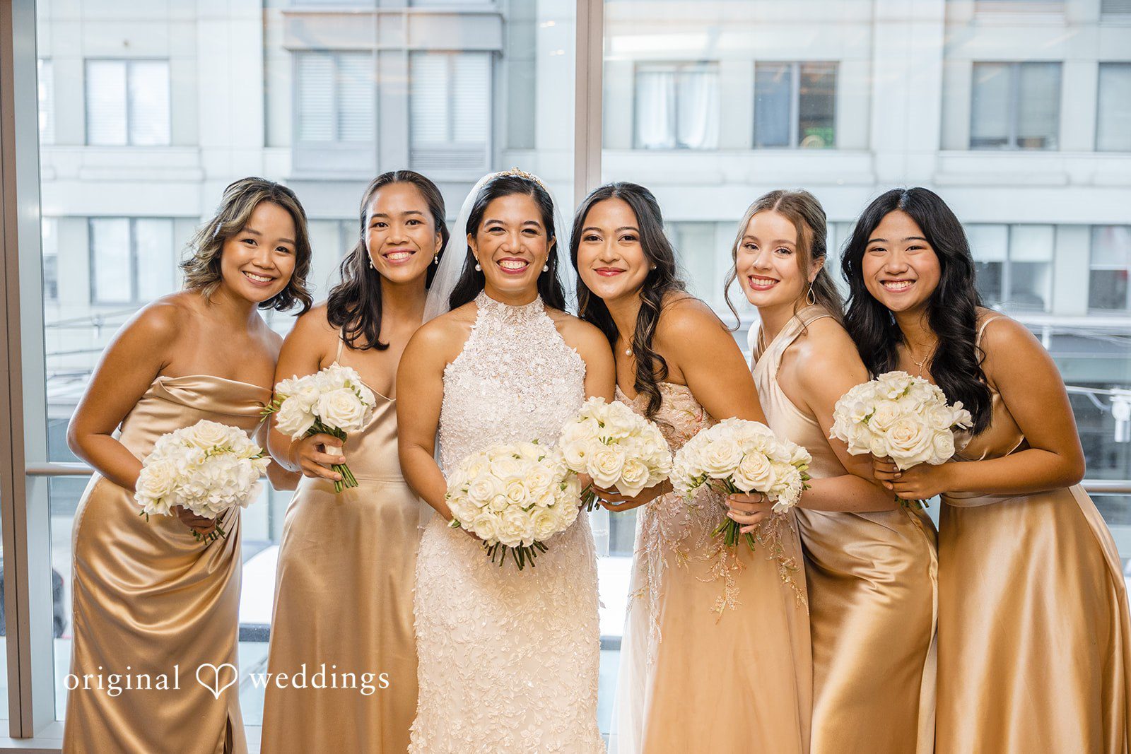 John + Michelle Group of bridesmaids wearing matching dresses posing together.