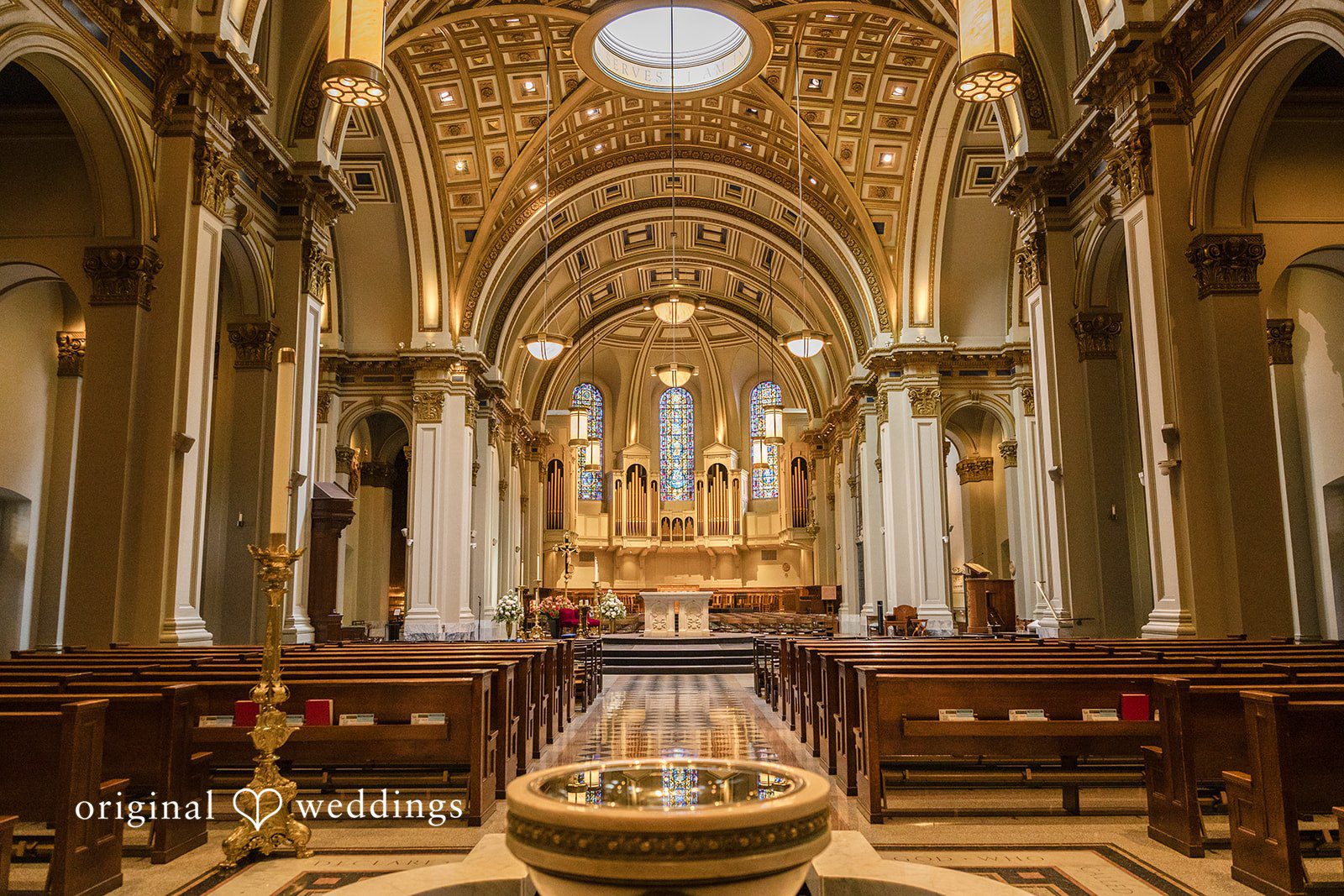 John + Michelle Grand cathedral interior featuring an ornate altar and rows of wooden pews.