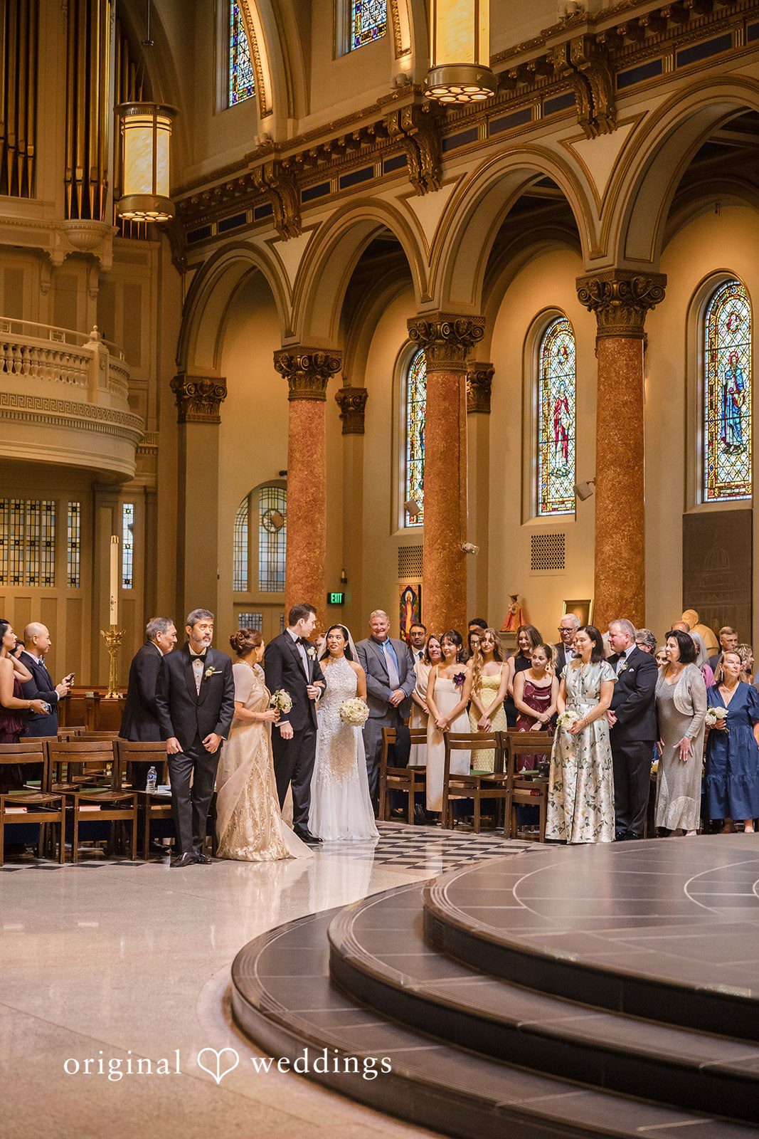 John + Michelle Wedding ceremony in progress inside a spacious cathedral.
