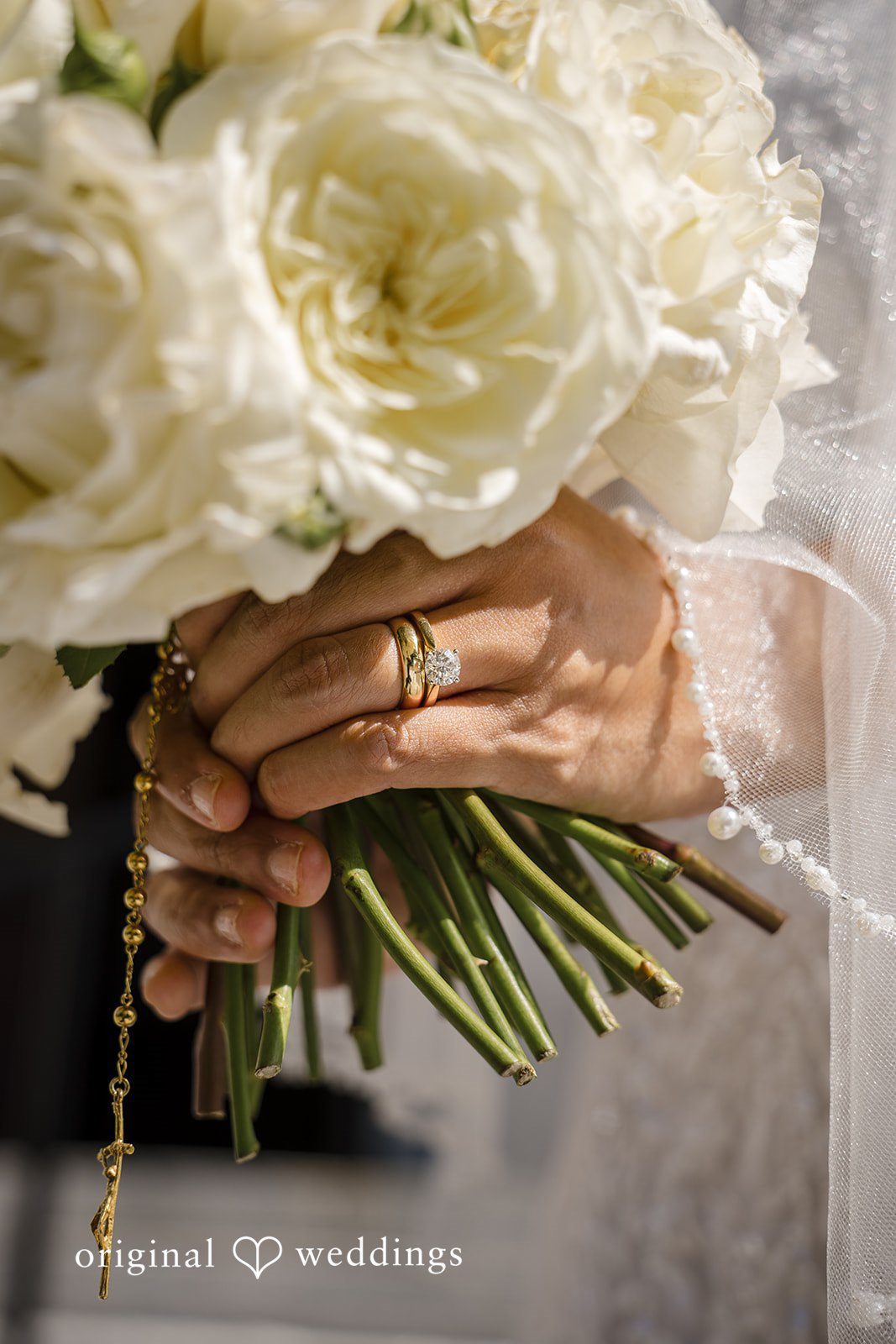 John + Michelle Close-up view of a person holding a large bouquet of white roses.