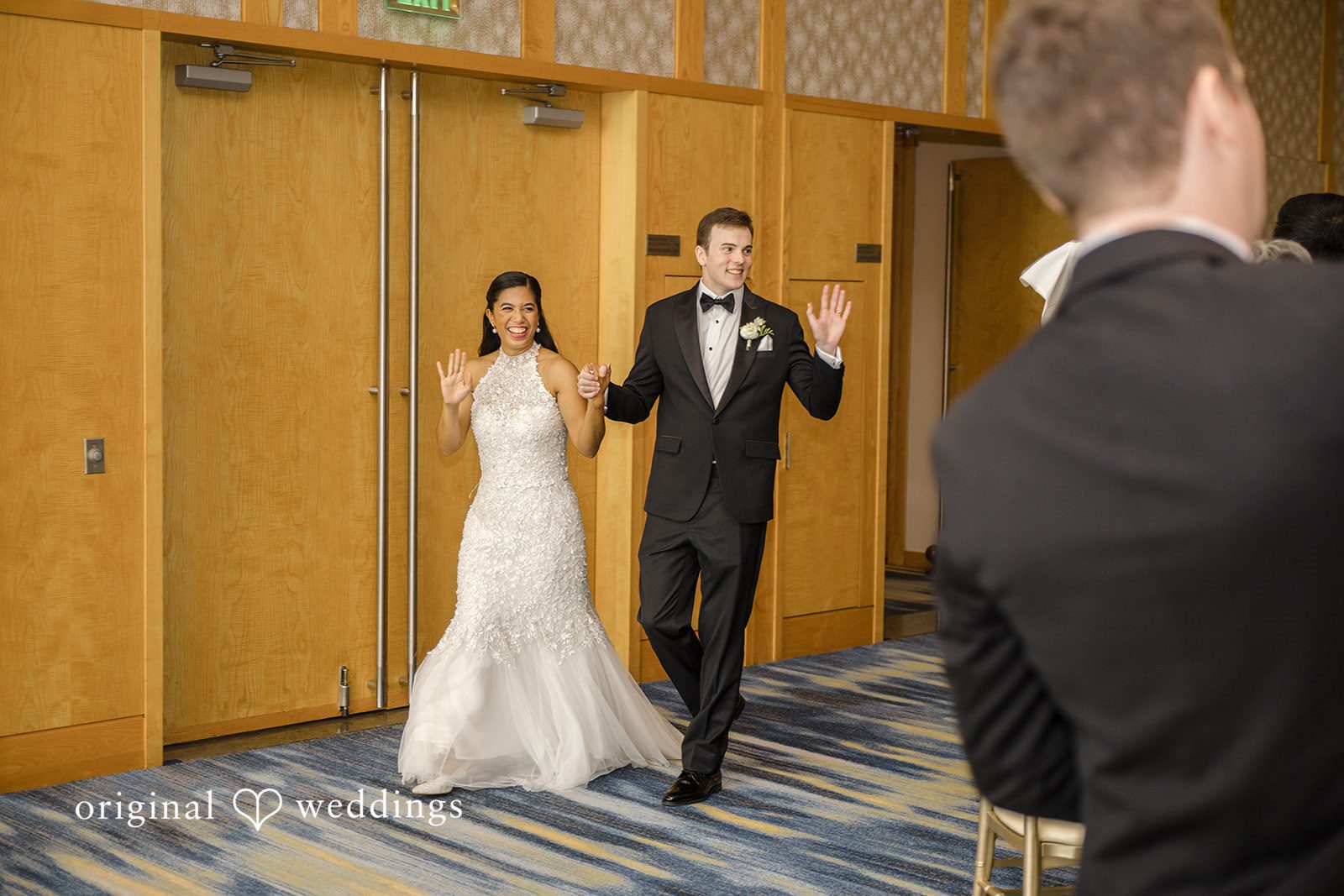 John + Michelle Bride and groom making their grand entrance into a reception hall.