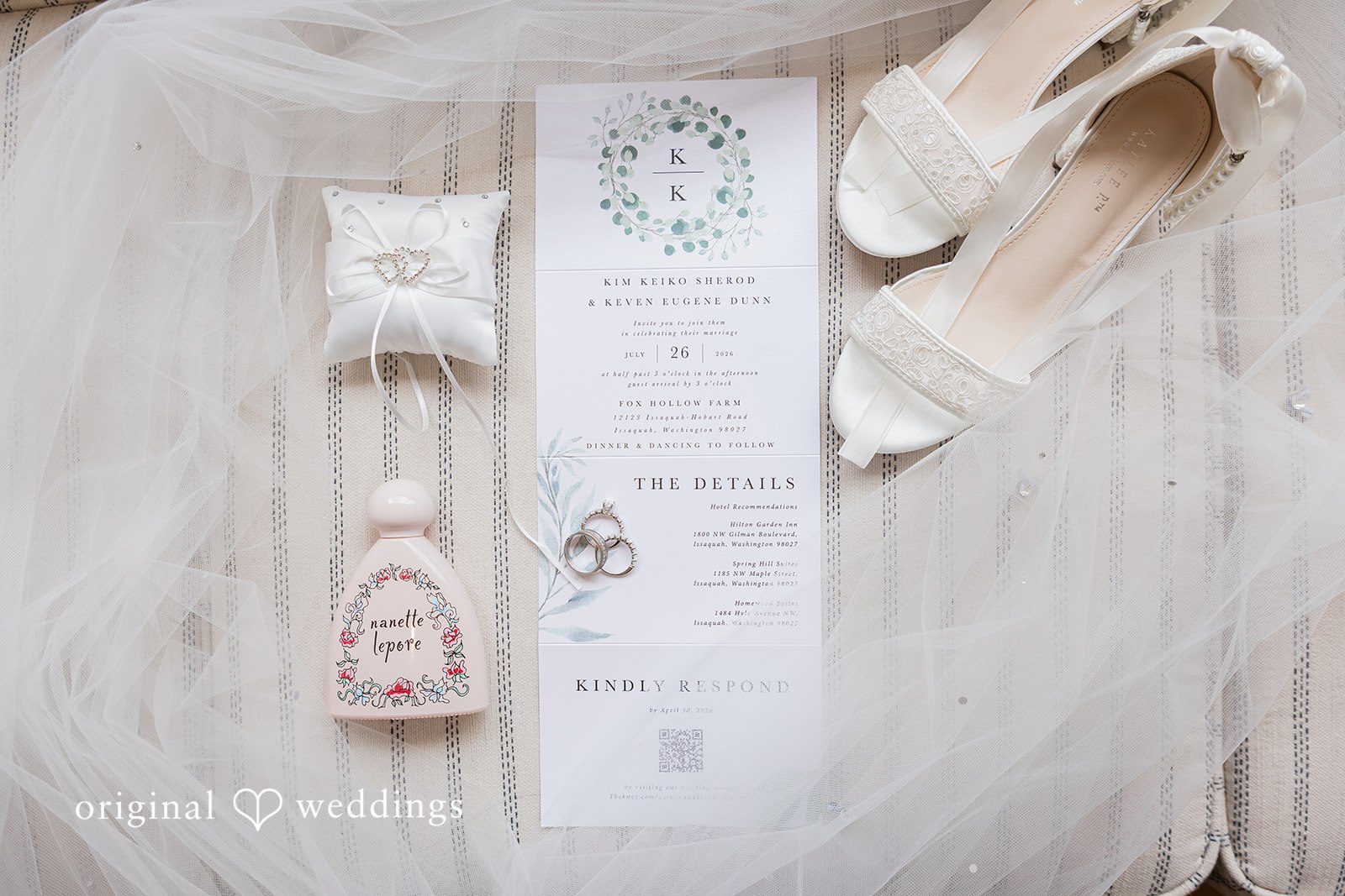 Kim + Keven A flat lay of wedding stationery, rings, and bridal shoes.